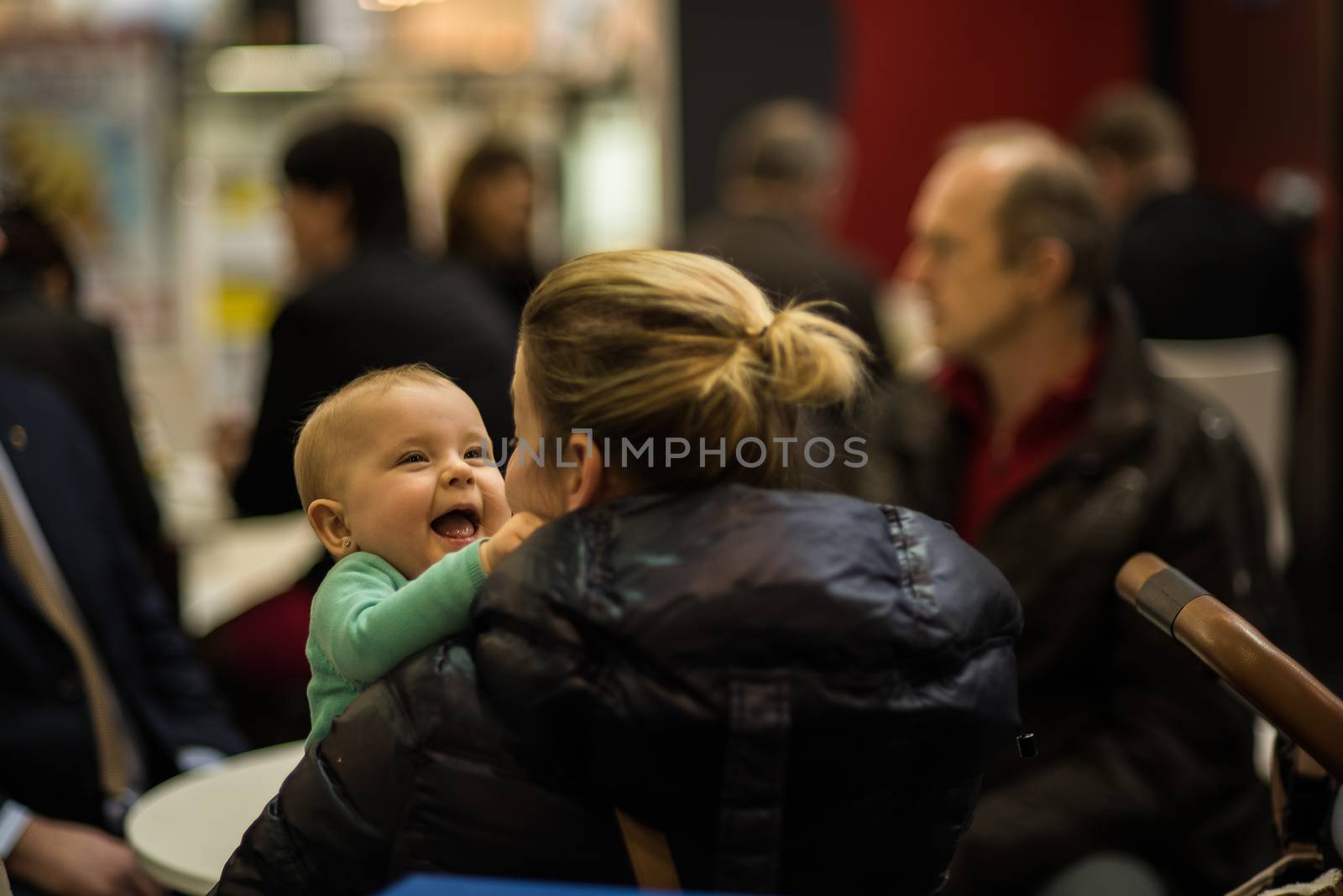 Beautiful child smiling and having fun with her mother while attending an event at the convention trade center in Brno. BVV Brno Exhibition