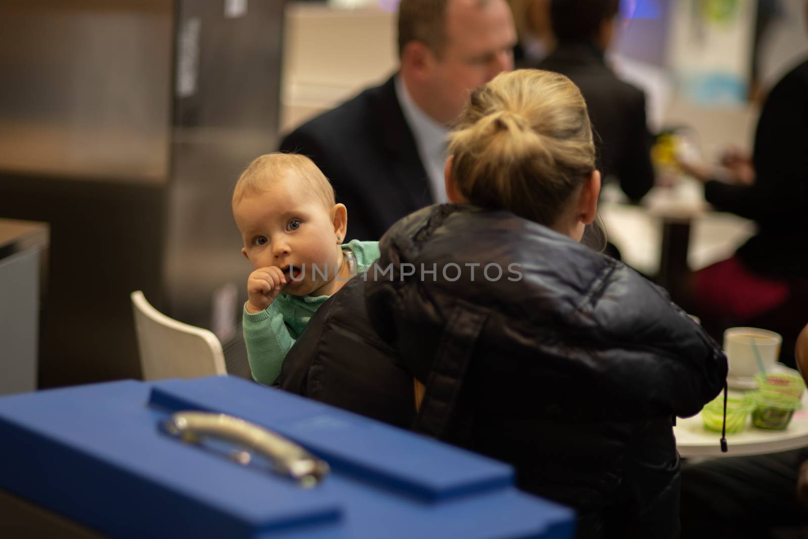 Beautiful small child looking at he camera and having fun with her mother while attending an event at the convention trade center in Brno. BVV Brno Exhibition
