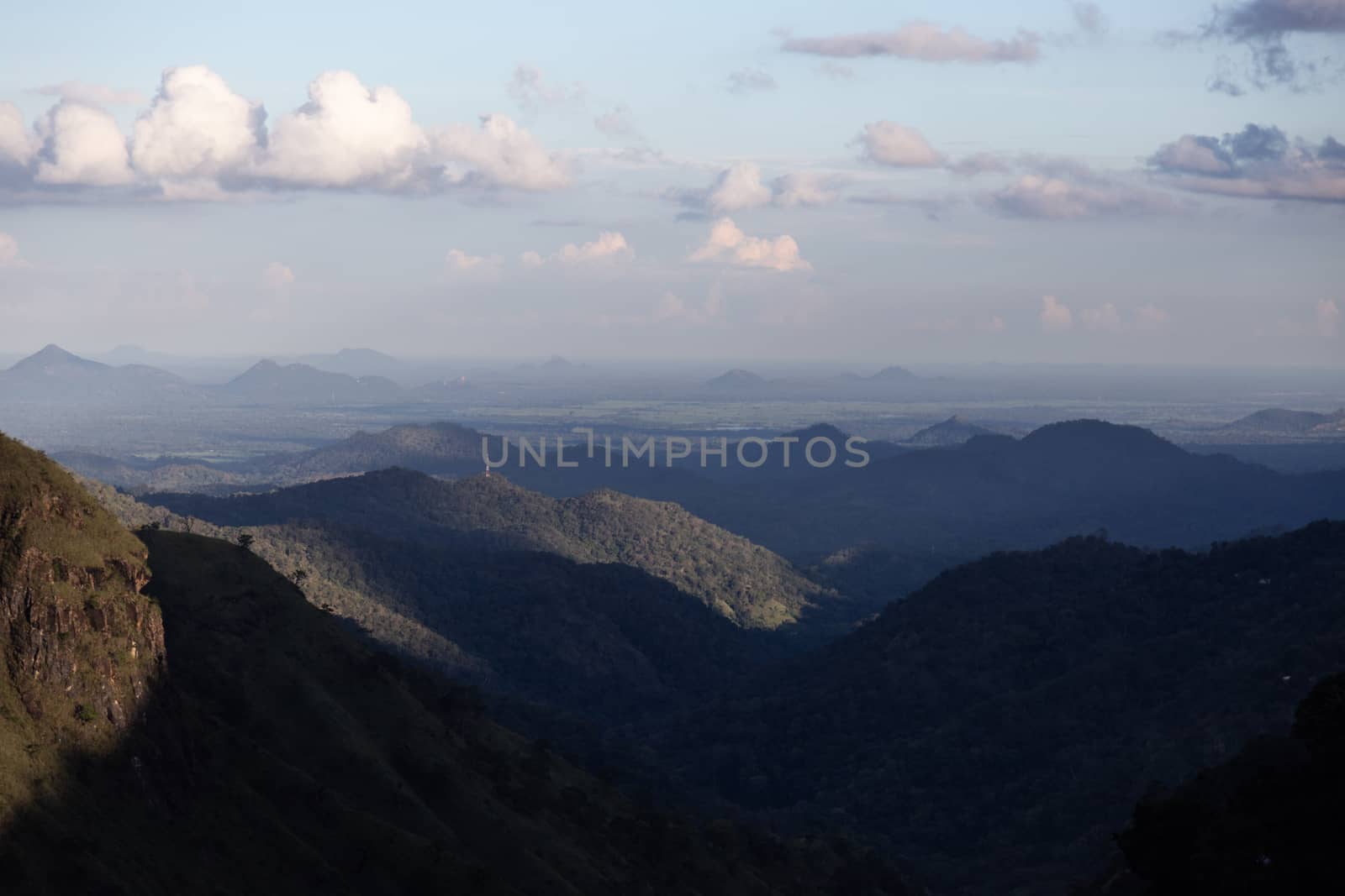 Ella Sri Lanka mountain gap landscape views across the wide valley to mountains in the distance against blue skies with clouds Adams Peak. High quality photo