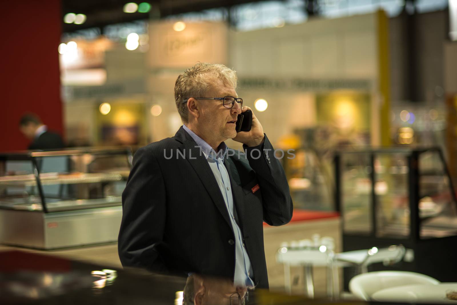 Business man speaking with her phone at the convention trade center in Brno. BVV Brno Exhibition center. Czech Republic