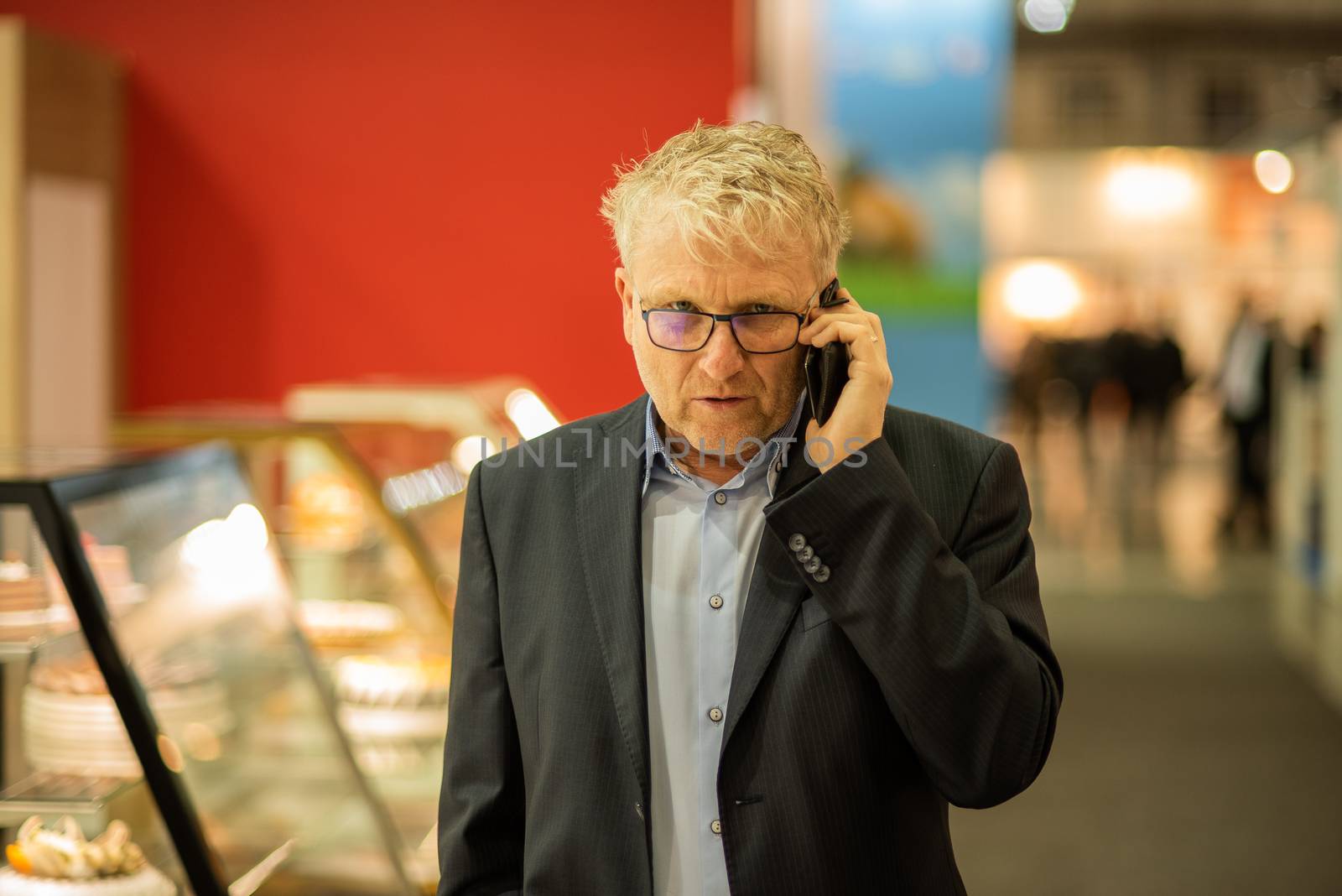 03/04/2018. Brno, Czech Republic. Business man speaking with her phone at the convention trade center in Brno. BVV Brno Exhibition center. Czech Republic by gonzalobell