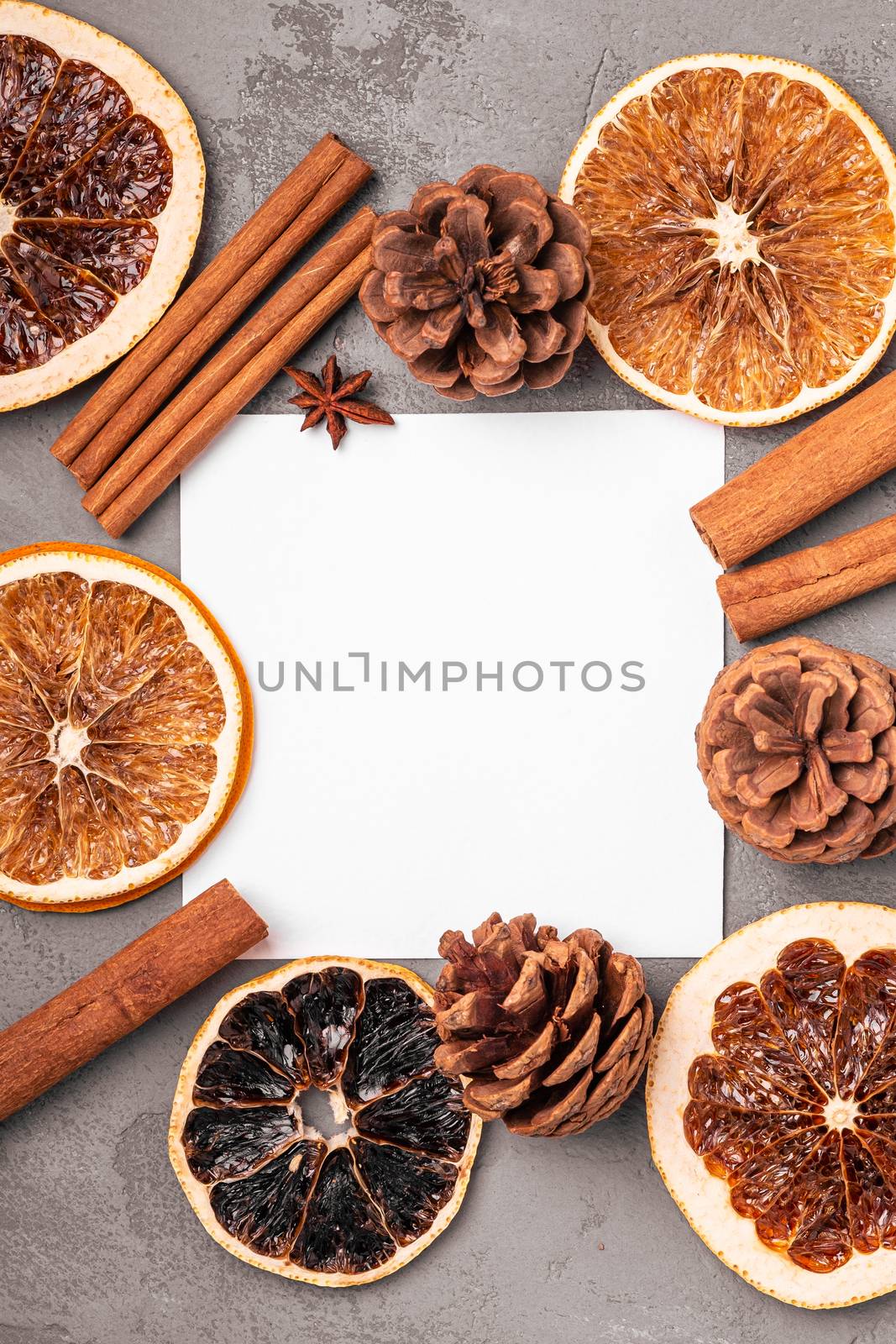 Christmas mockup composition. Cinnamon, anise, dried fruits and pine cones decorations on grey background