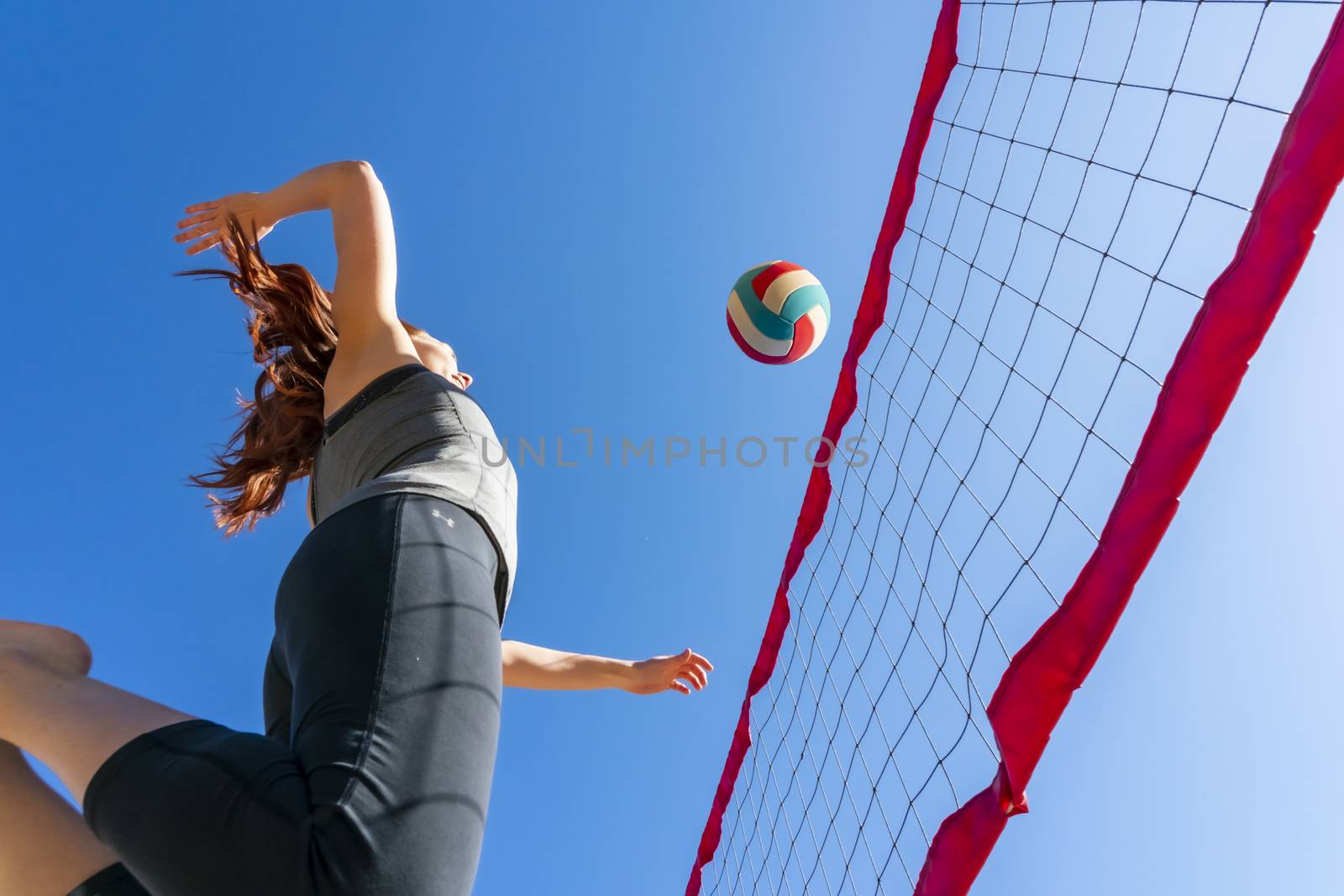 A Gorgeous Redhead Fitness Model Preparing To Play Volleyball by actionsports