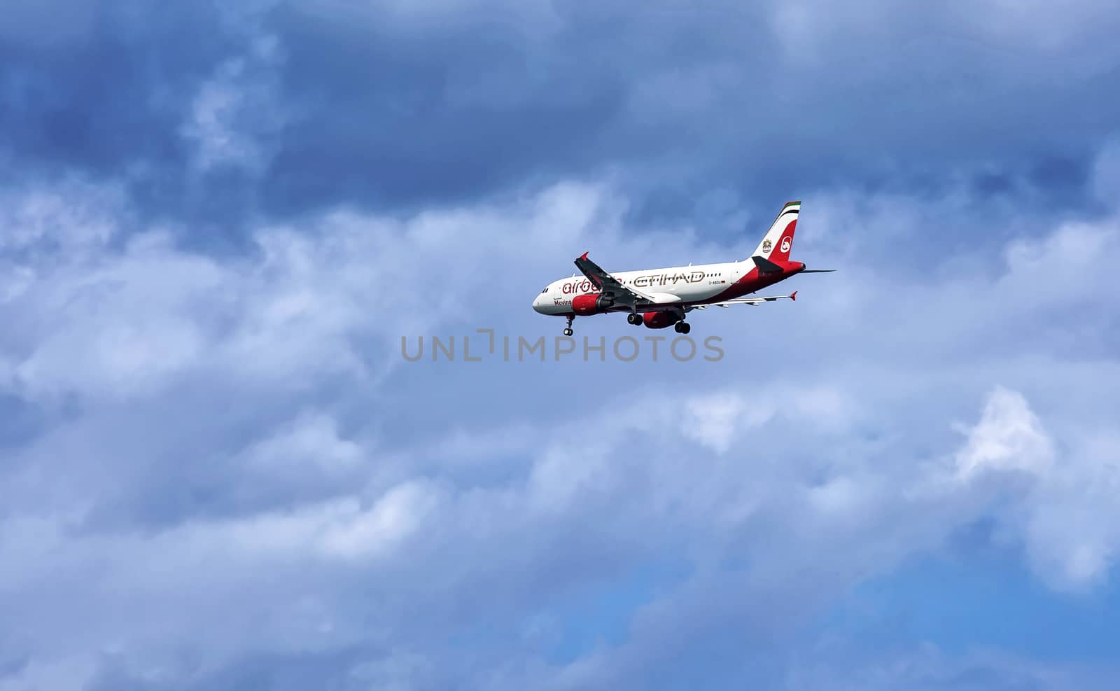 Passenger aircraft sets to land among cumulus clouds by Grommik