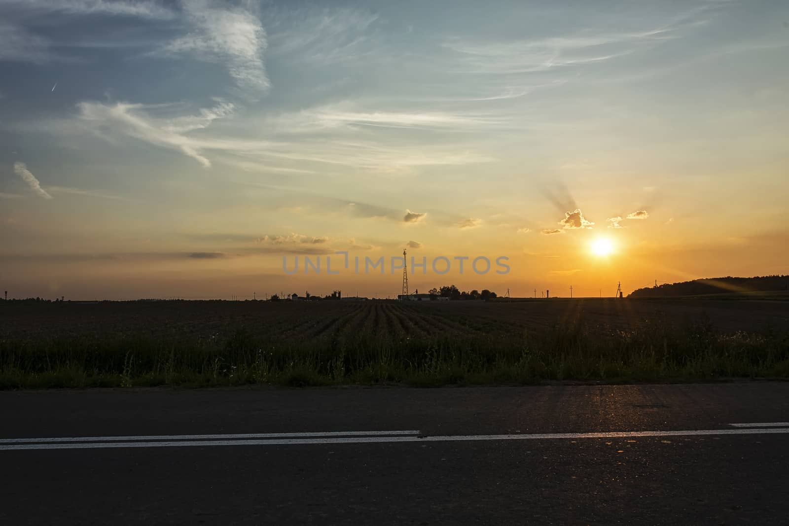 Evening landscape. Sunset in a field in the clouds
