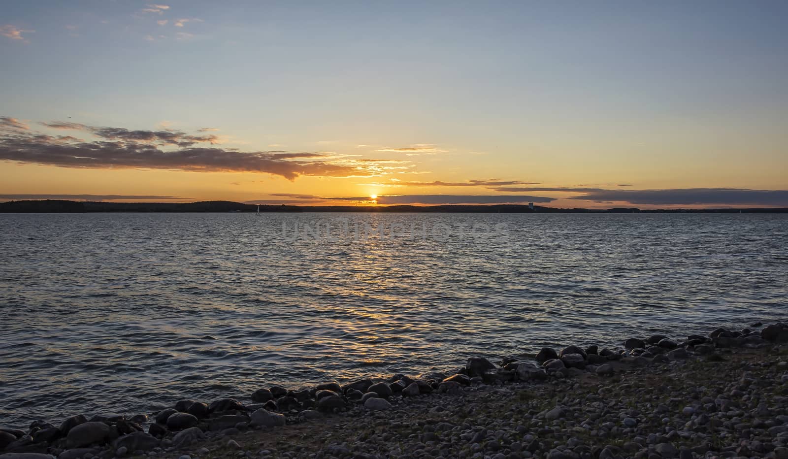 Evening landscape. Sunset in the clouds on the pond