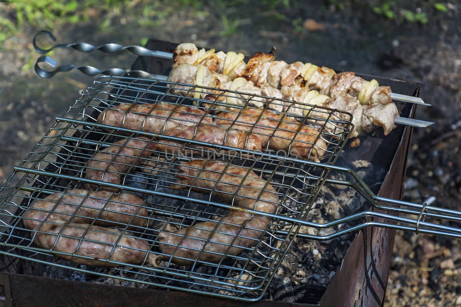On the grill roasted sausages on the grill and shish kebab on skewers