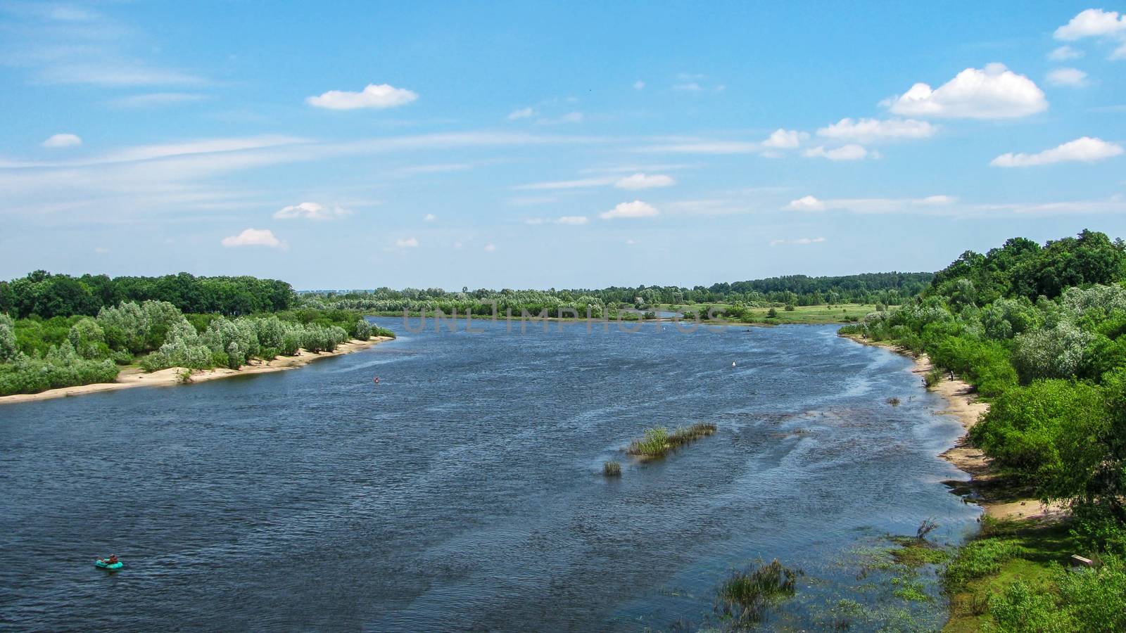 Summer landscape. River with trees on the banks flowing beyond the horizon          