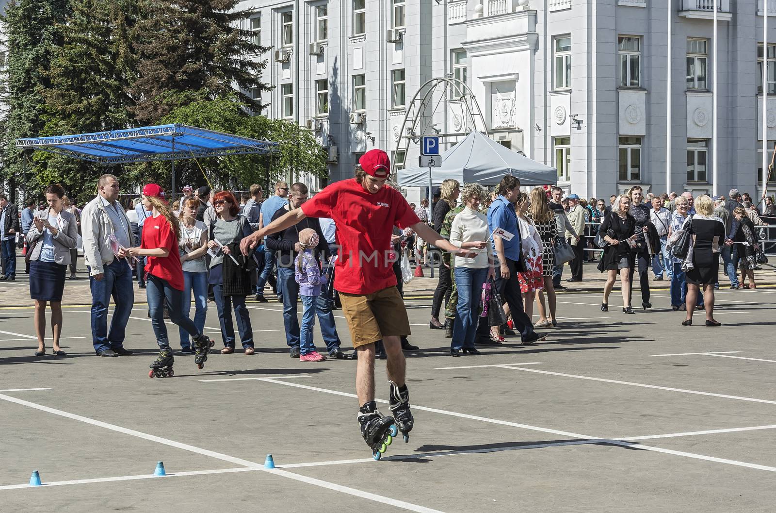 Belarus, Minsk - 27.05.2017: A young man in a red T-shirt and shorts is riding roller skates
