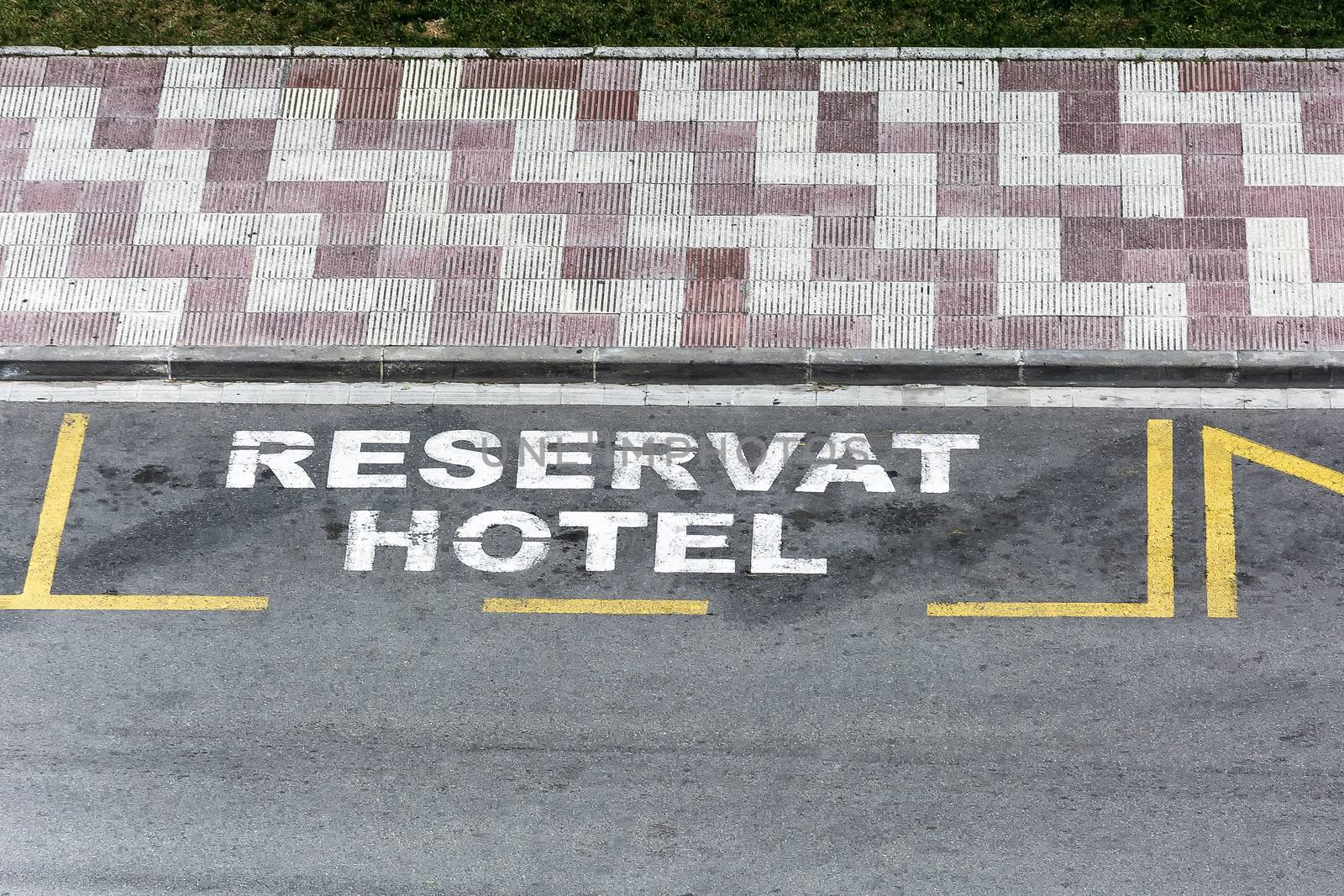 On the roadway of the city street there is a marking with the inscription "Reservat hotel"