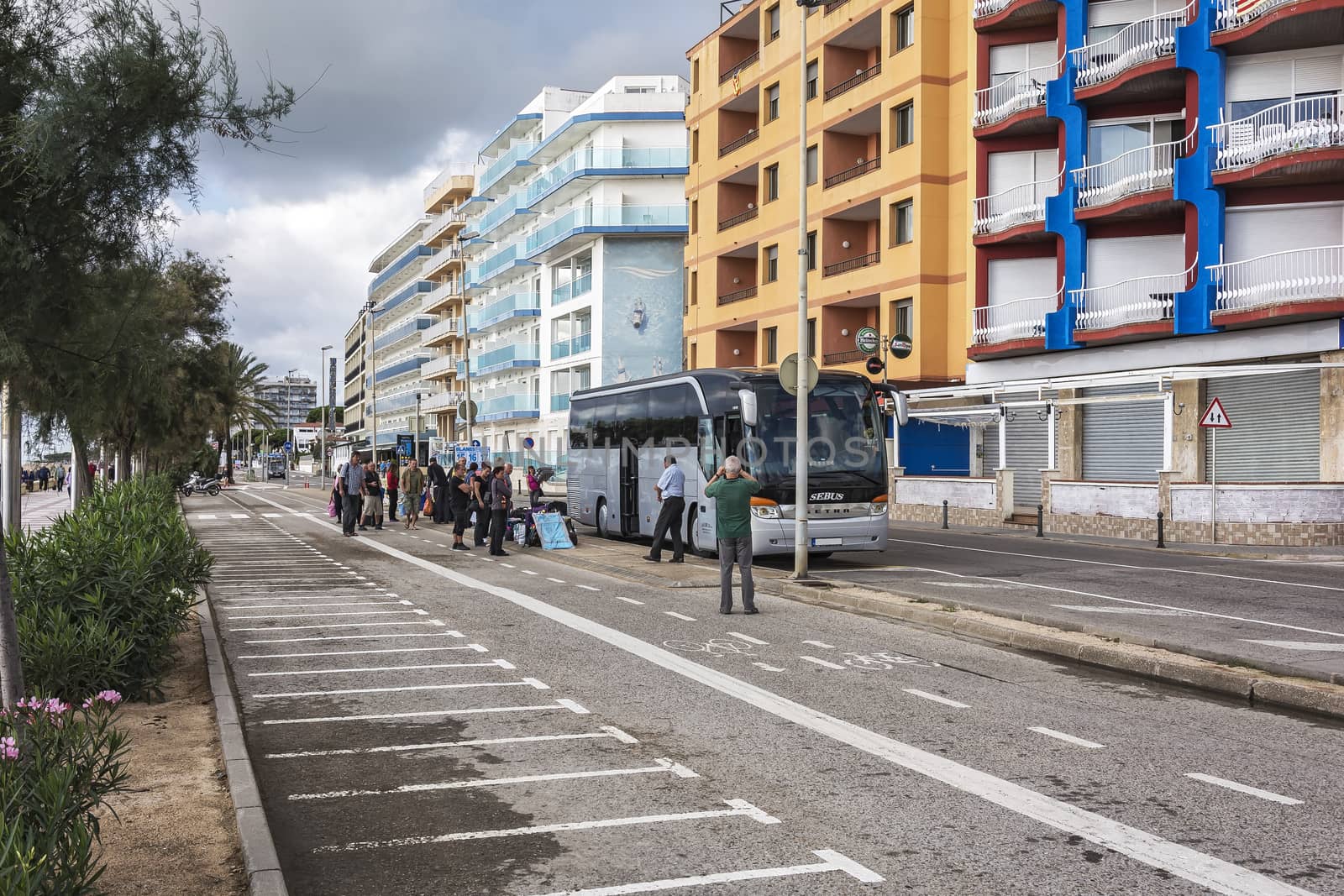 Passengers boarding a bus on a city street (Blanes, Spain) by Grommik