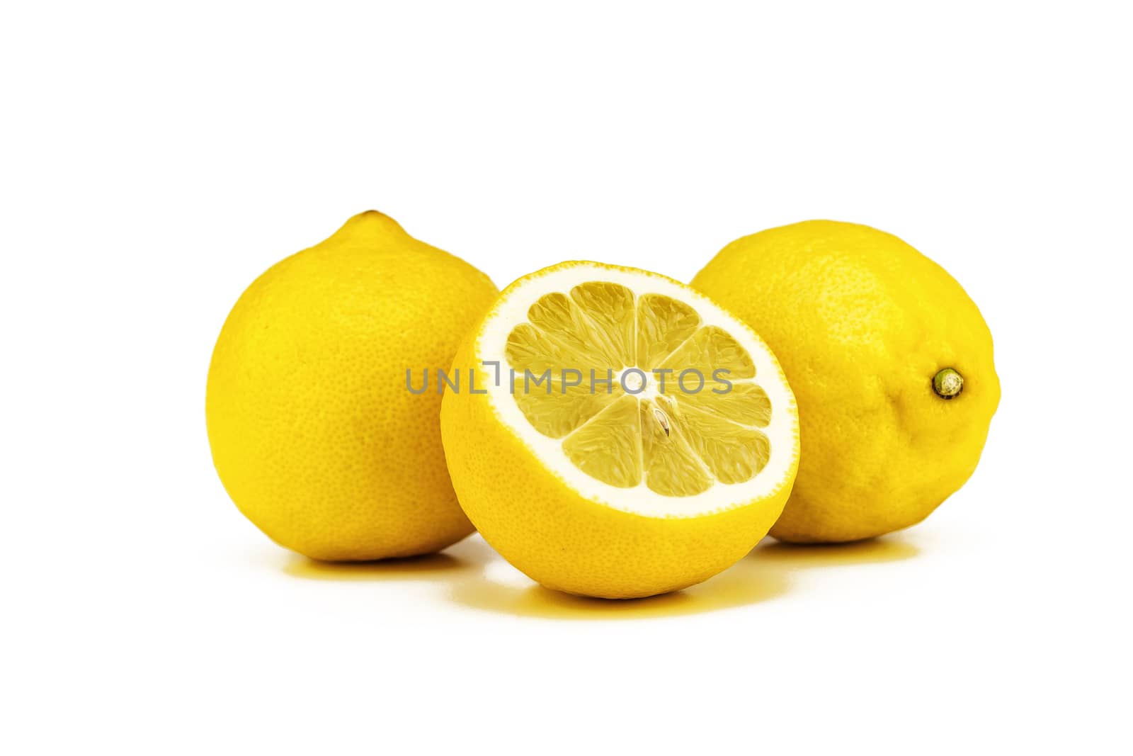 On a white background there are two whole yellow lemons and one cut half
