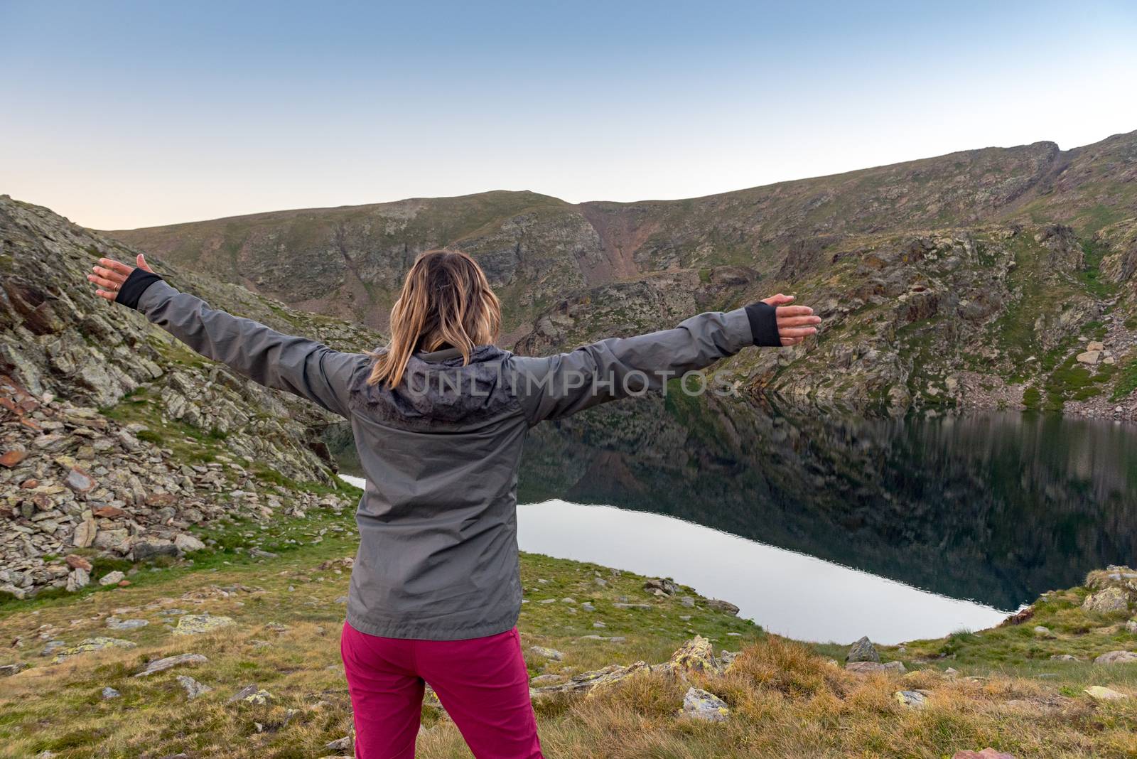 Woman in the Vall de Riu lake from the Estanyo peak in Andorra in summer 2020.