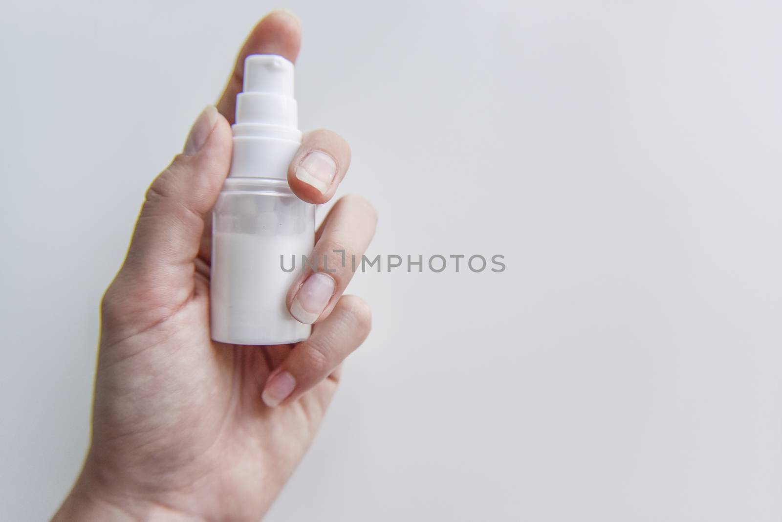 holding in hand the tube with some white liquid in it, cosmedics and hygene concept