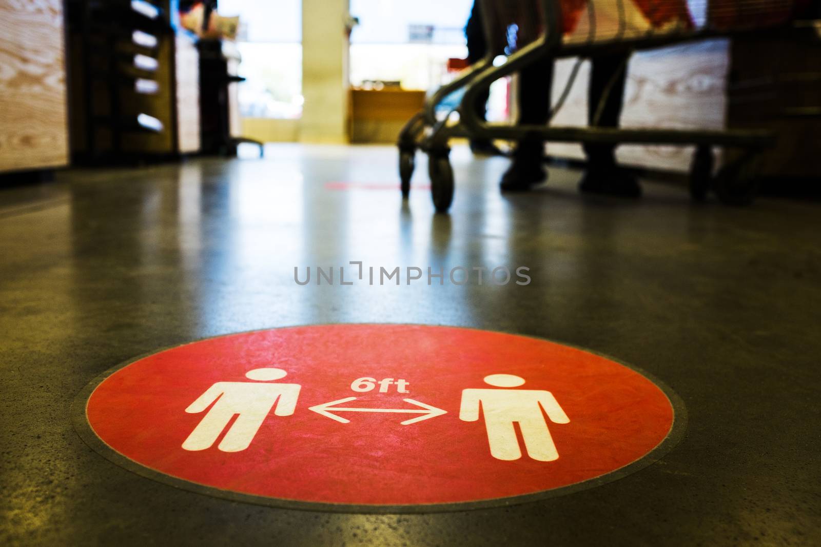 Red circle symbol sign printed on ground at US supermarket cash register cue informing people to keep 6 feet distance from each other to prevent spreading Coronavirus COVID-19 virus disease infection