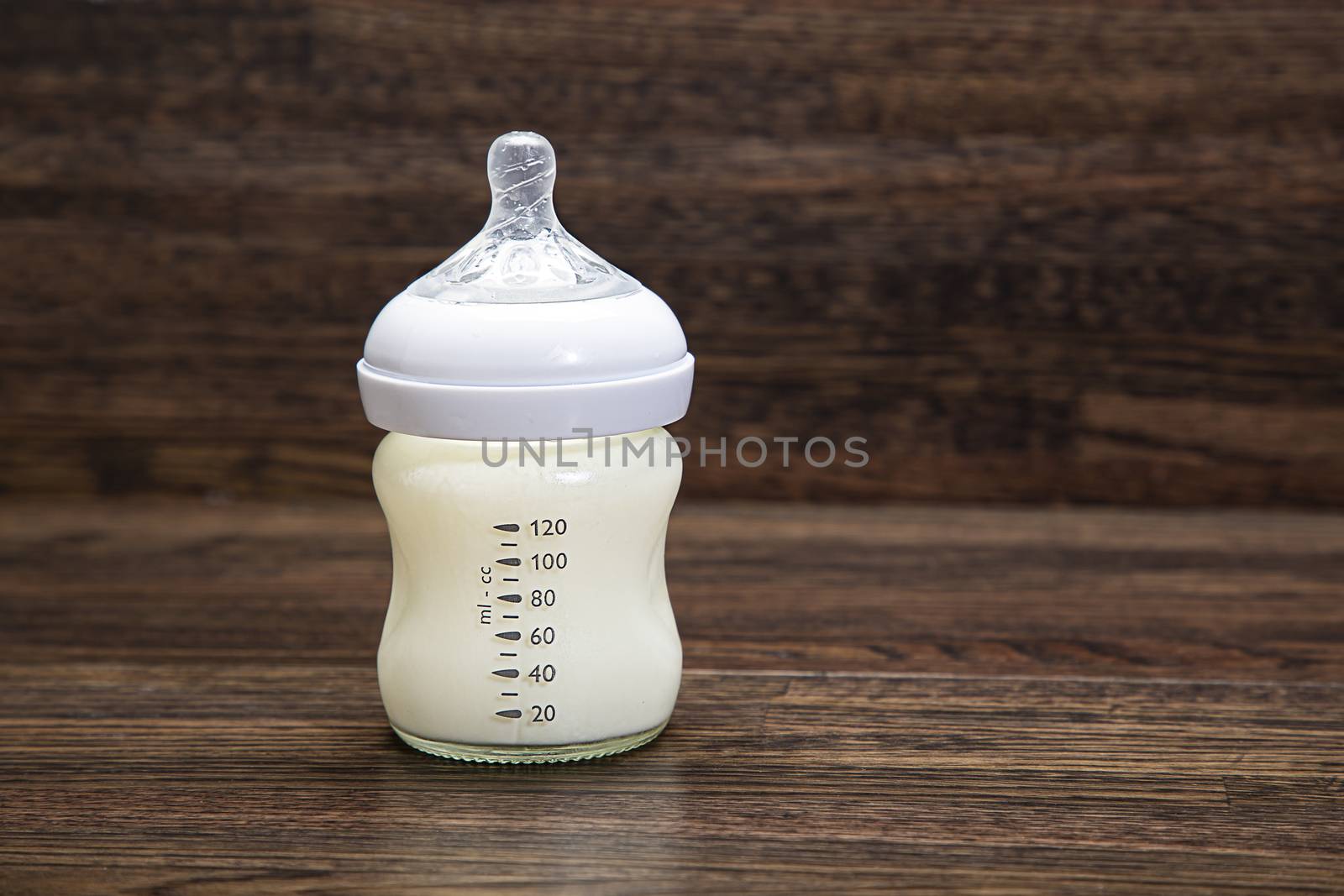 Small bottle of milk against a wood background