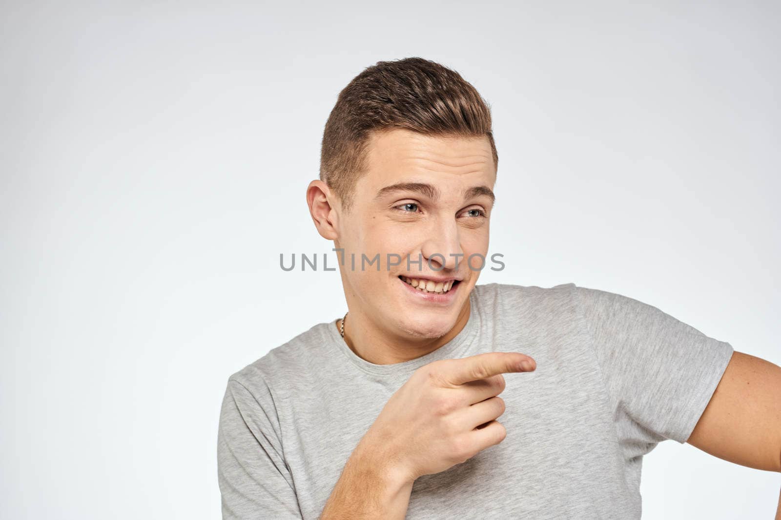 Handsome man in gray t-shirt cropped view of emotion Studio Model. High quality photo