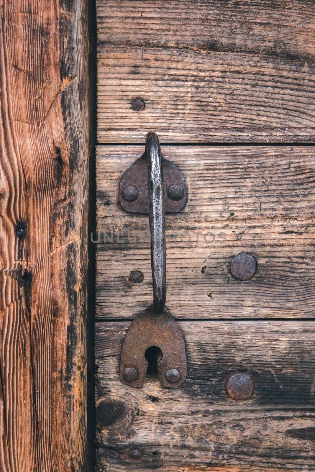 Metallic handle of door is in an old wooden house background