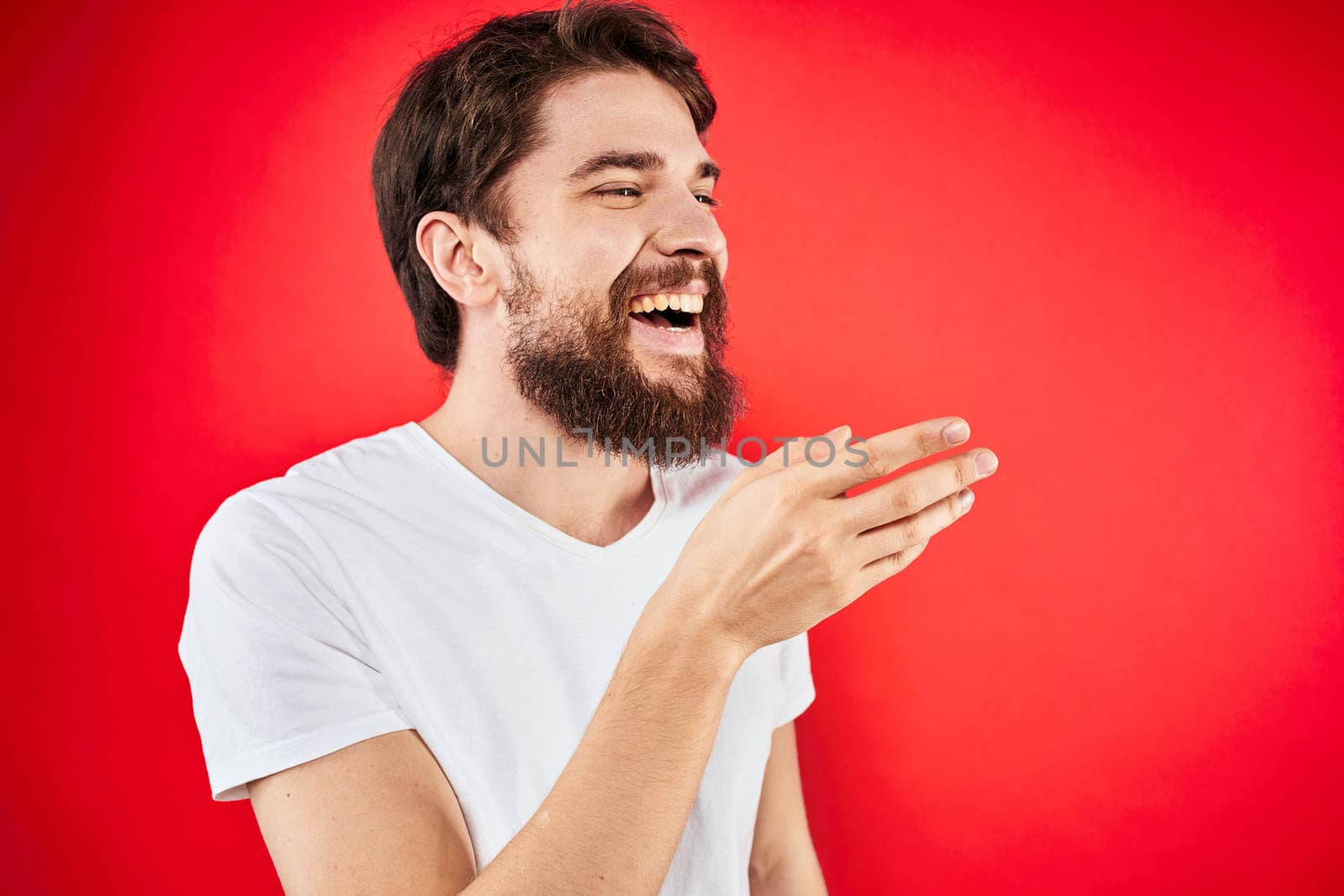 Bearded man fun emotions lifestyle cropped view white t-shirt red background. High quality photo