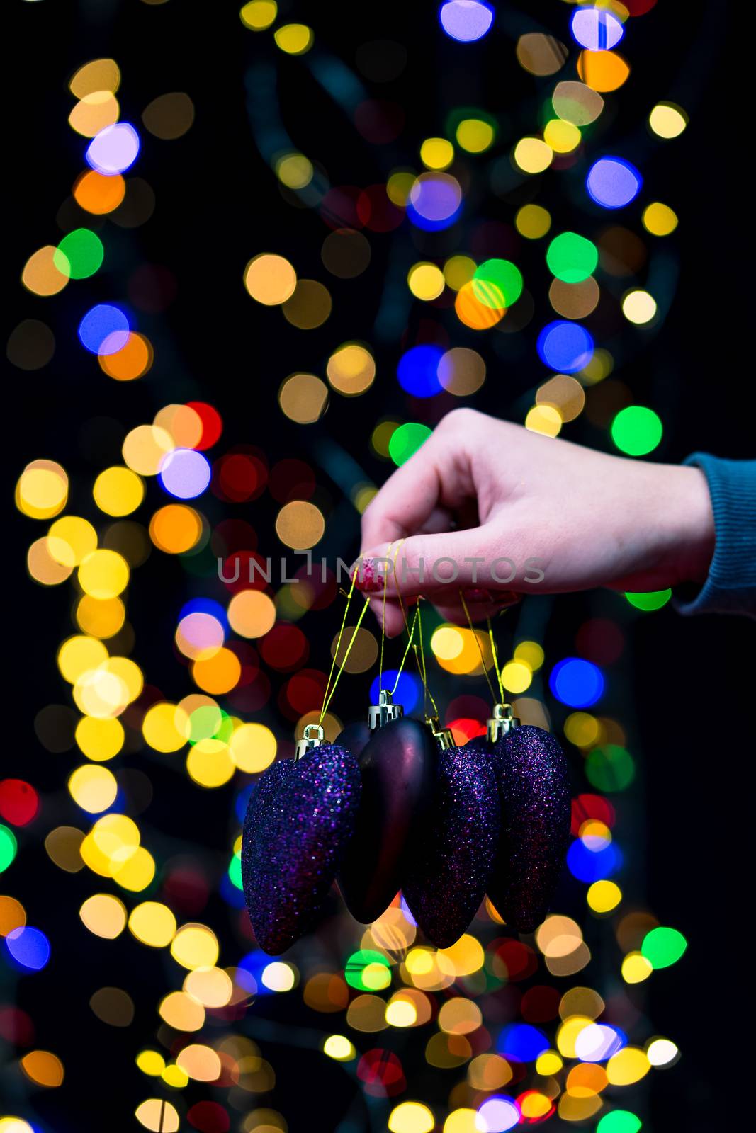 Woman's hands hold christmas decoration. Christmas and New Year holidays background, winter season with Christmas ornaments and blurred lights