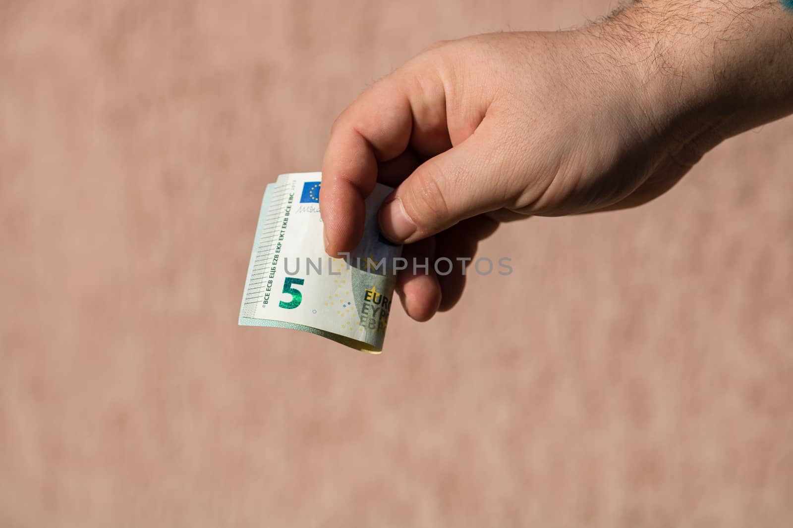 Man hands giving money like a bribe or tips. Holding EURO banknotes on a blurred background, EU currency