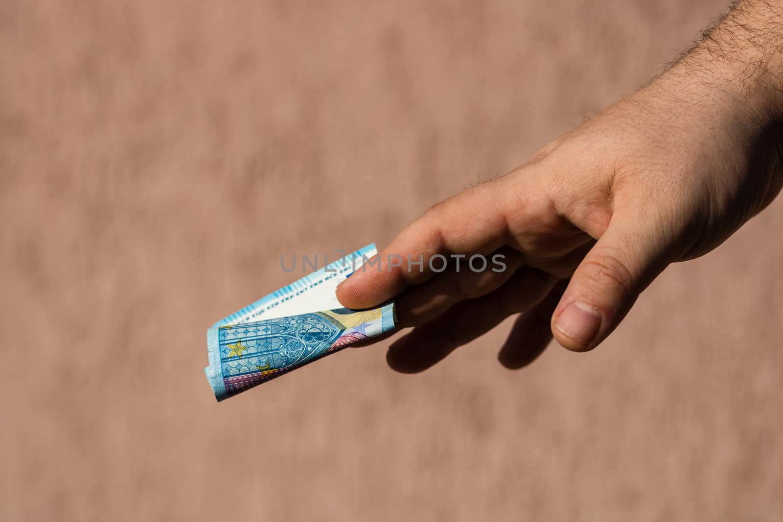 Man hands giving money like a bribe or tips. Holding EURO banknotes on a blurred background, EU currency