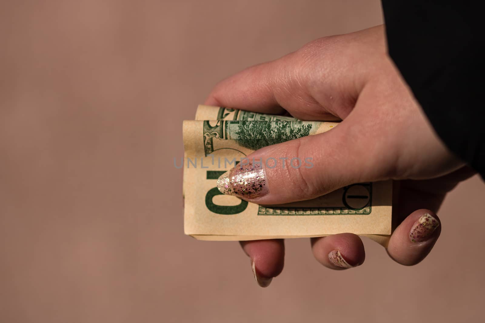 Hand holding or giving dollars money. Holding US dollars banknote on a blurred background, US currency