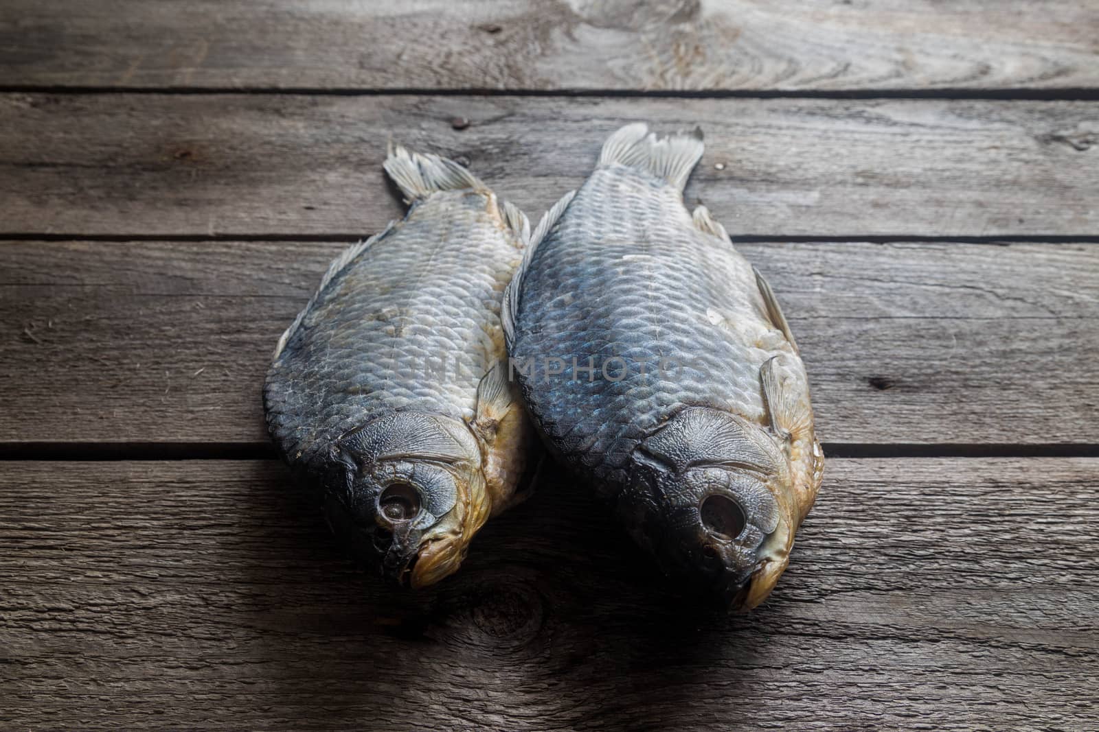 Salted Dry fish vobla on wooden background, delicious beer snack, close-up.