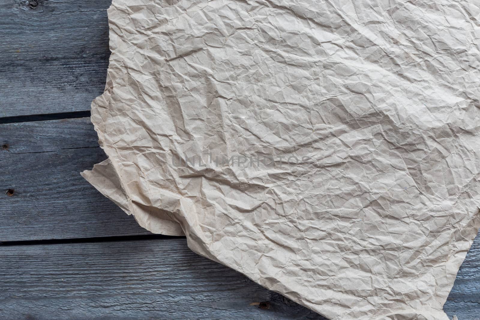 Crumpled craft paper on wooden background, copy space by galinasharapova