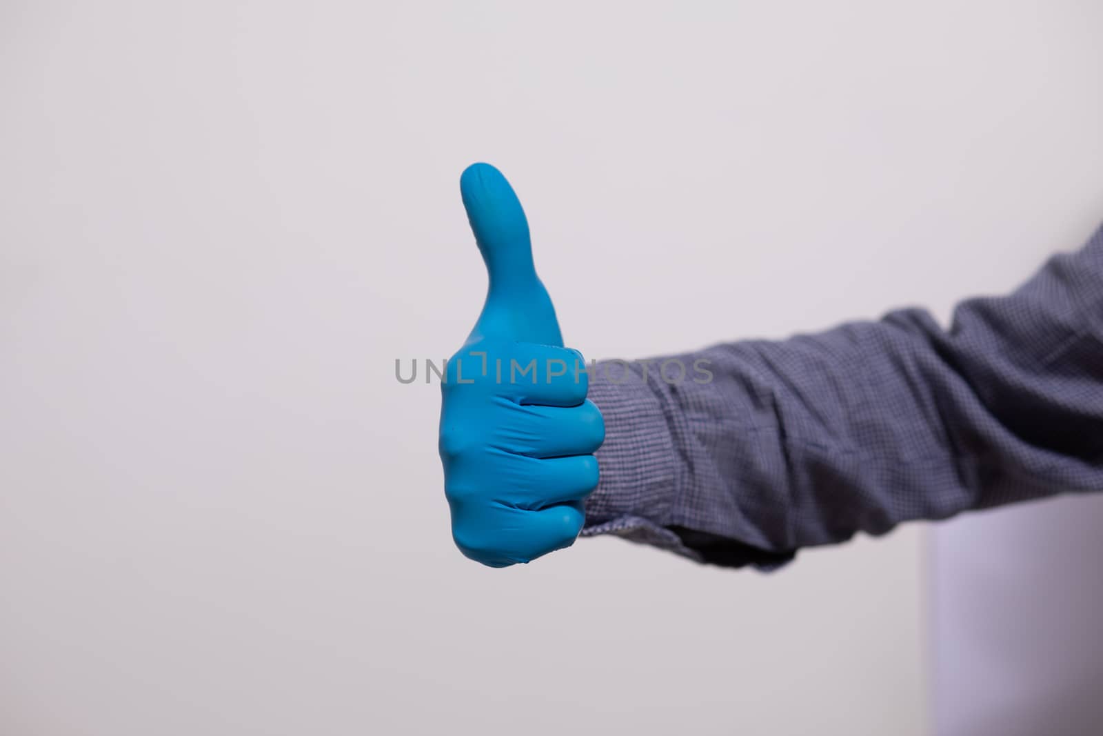 Man Wearing Gloves For Protection From Viruses and showing "like" gesture Stock Photo