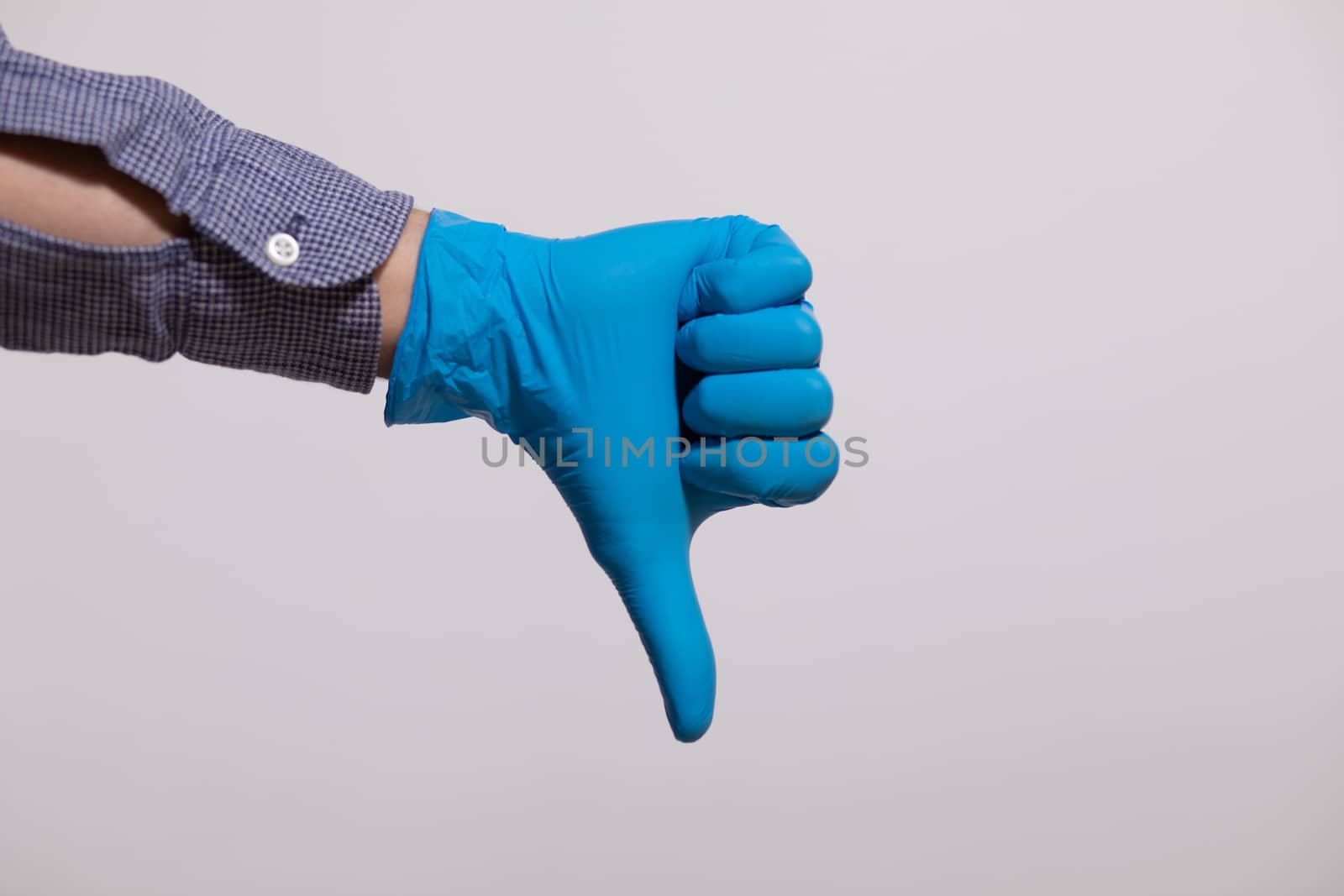 Man Wearing Gloves For Protection From Viruses and showing "dislike" gesture
