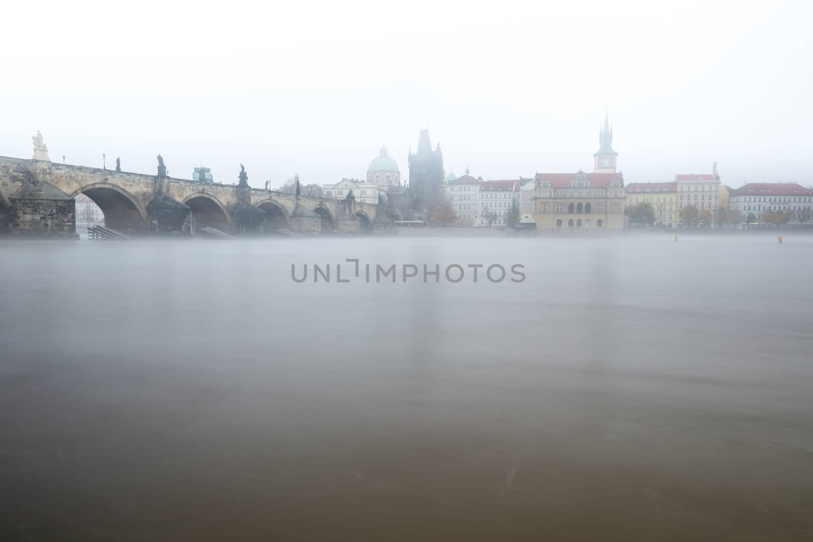 Autumn dawn in historic Prague at Charles Bridge over the Vltava River. Prague, ENESCO monument, Czech Republic