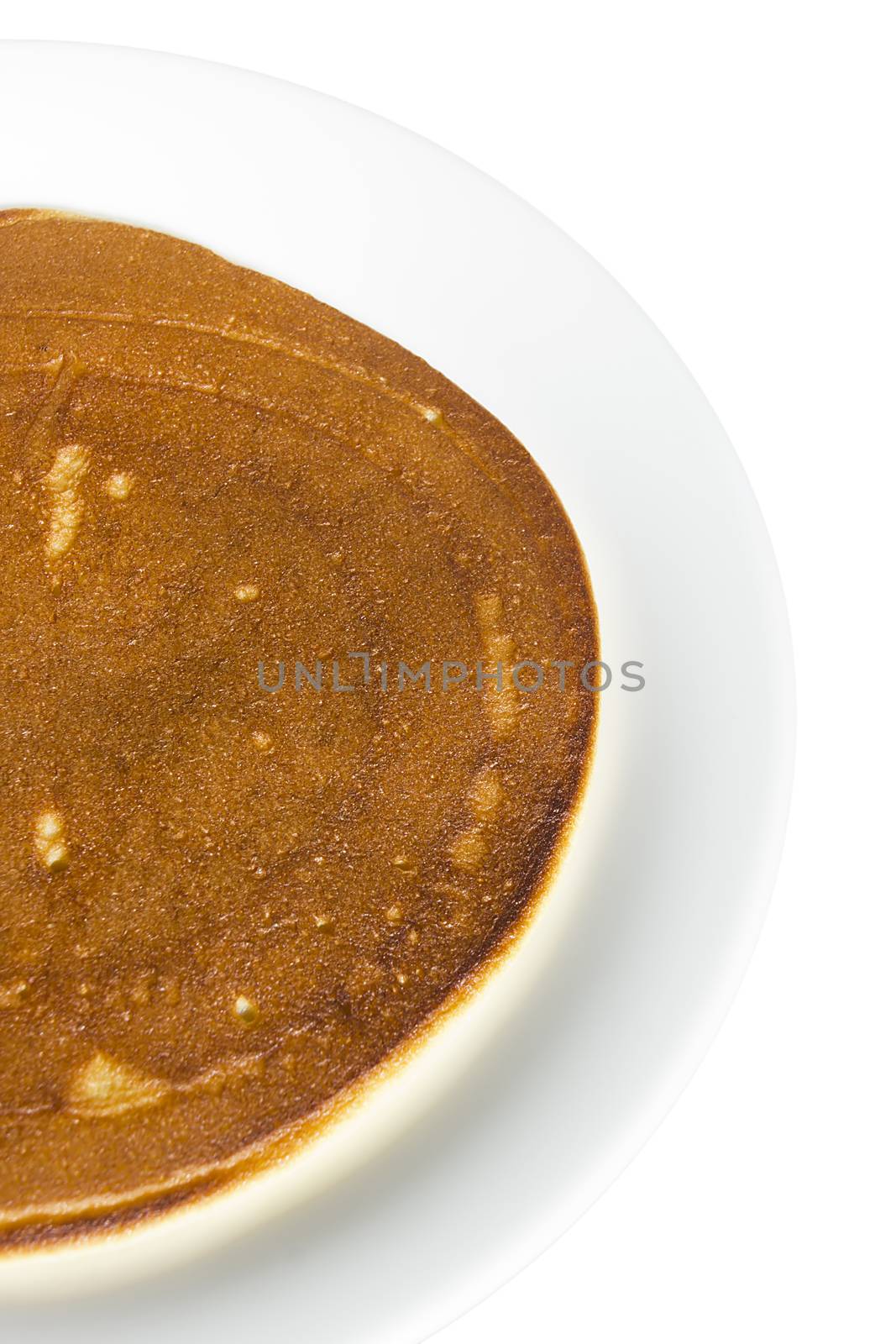 Freshly baked pancake on a plate on a white background