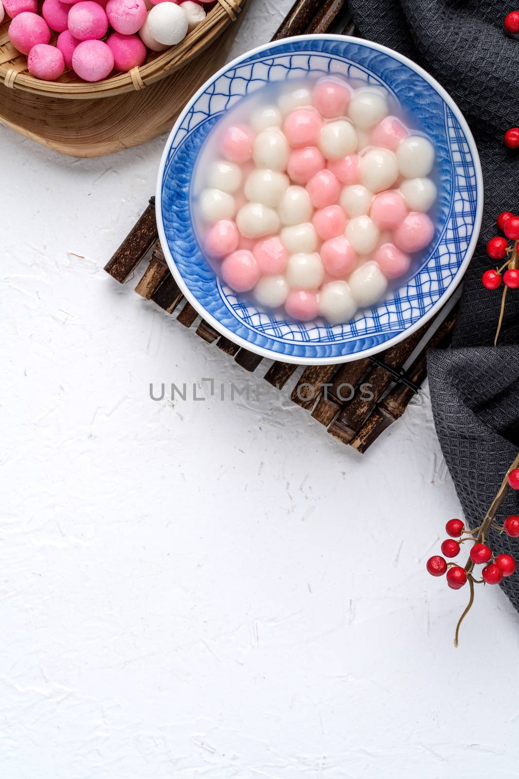 Top view of red and white tangyuan in blue bowl on white backgro by ROMIXIMAGE