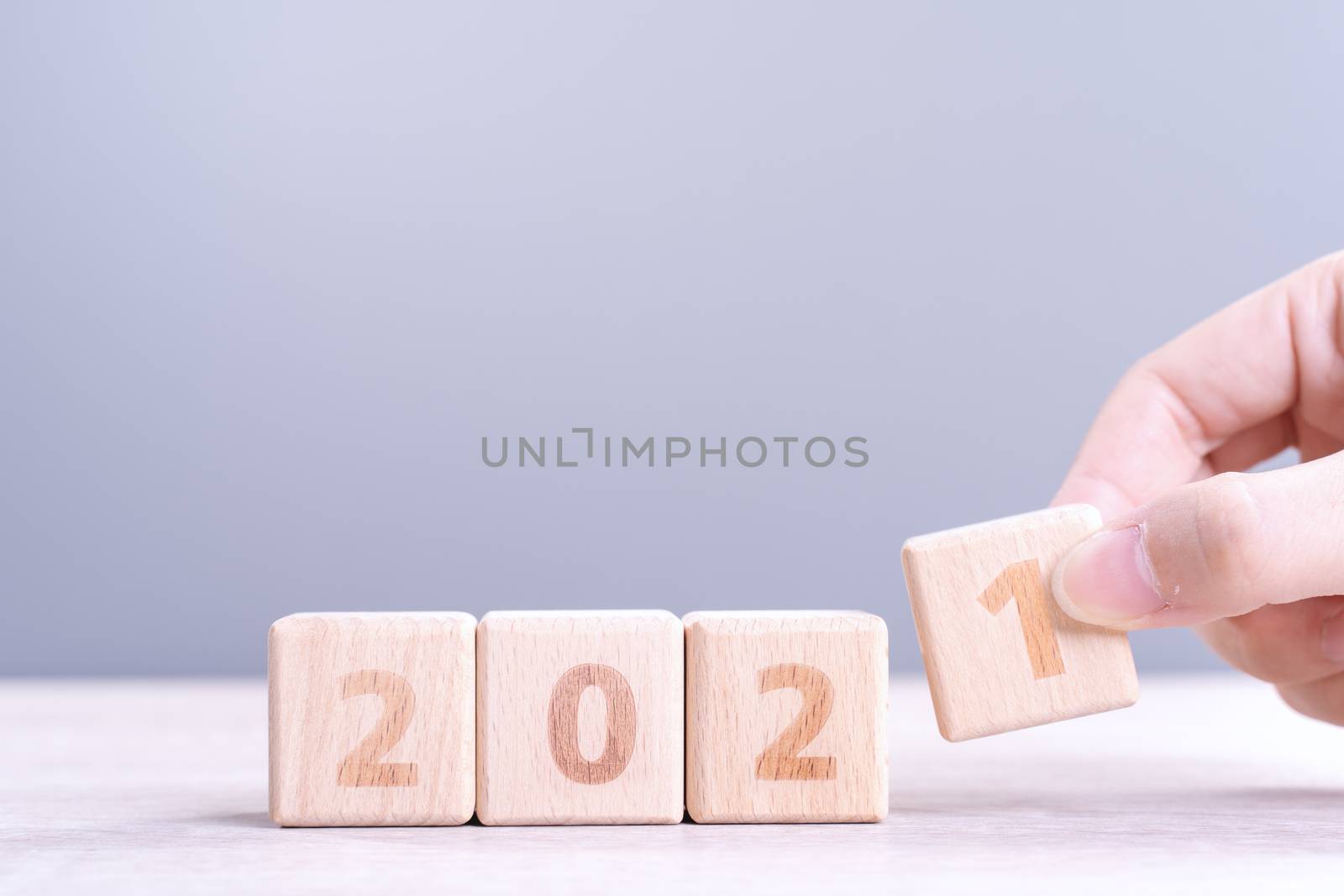 2021 New Year abstract design concept - Number wood block cubes isolated on wooden table and light mist blue background.