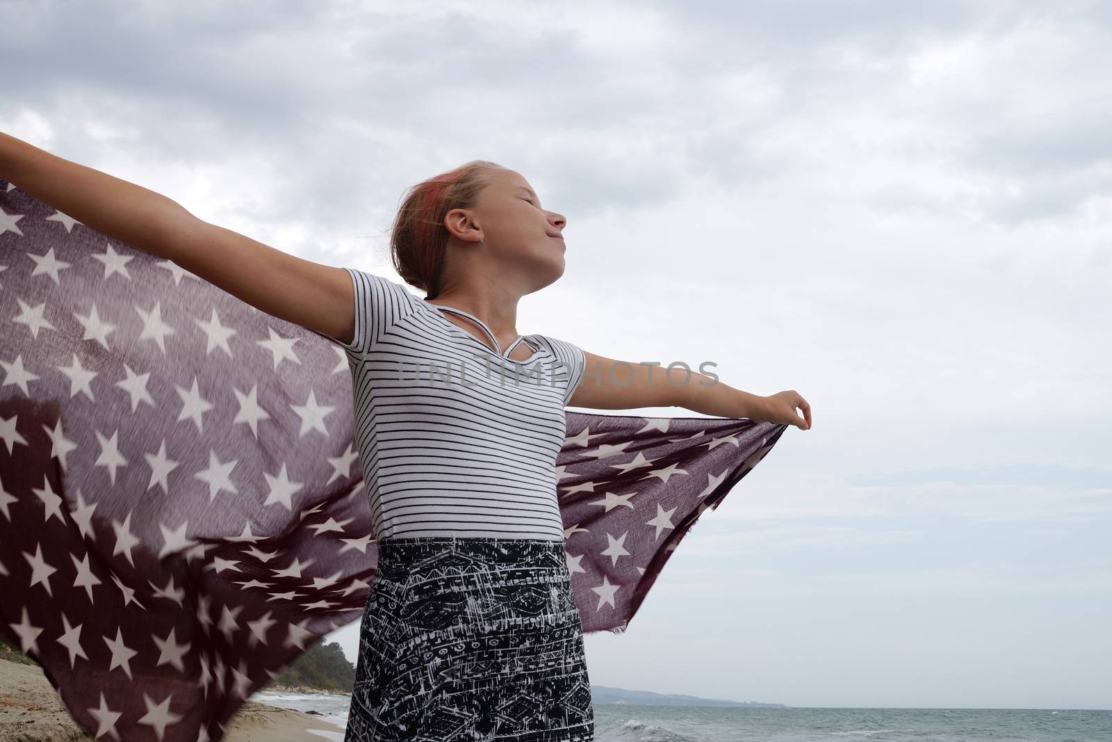 teenage girl with a handkerchief fluttering in the wind in her hands,