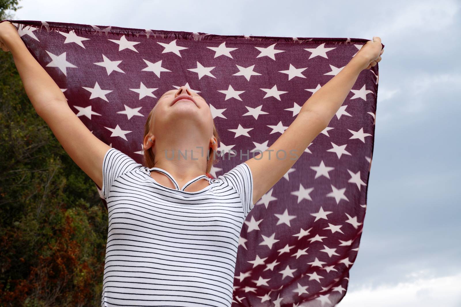 teenage girl with a handkerchief fluttering in the wind in her hands,