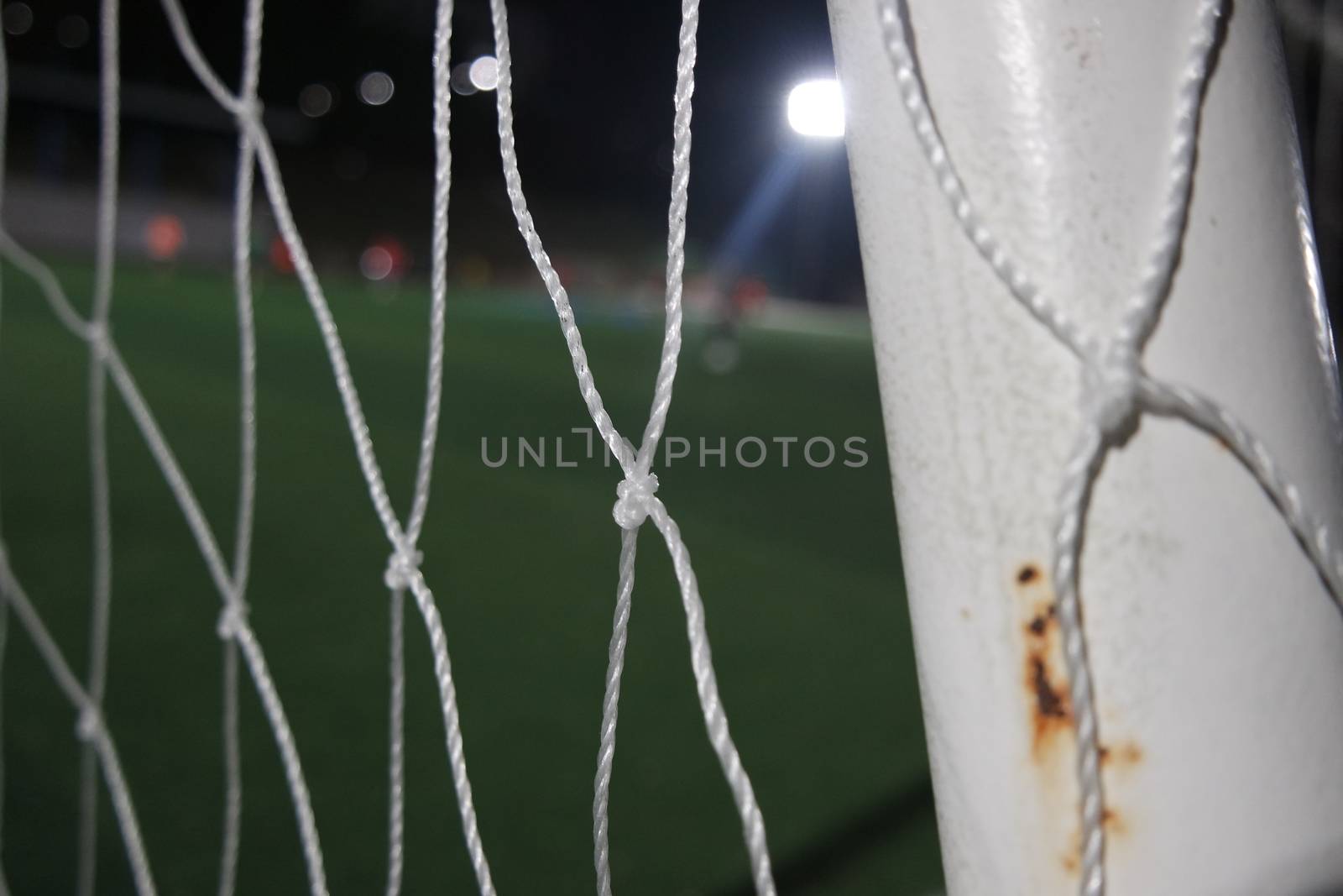 Closeup view of goal net in a soccer playground by Photochowk