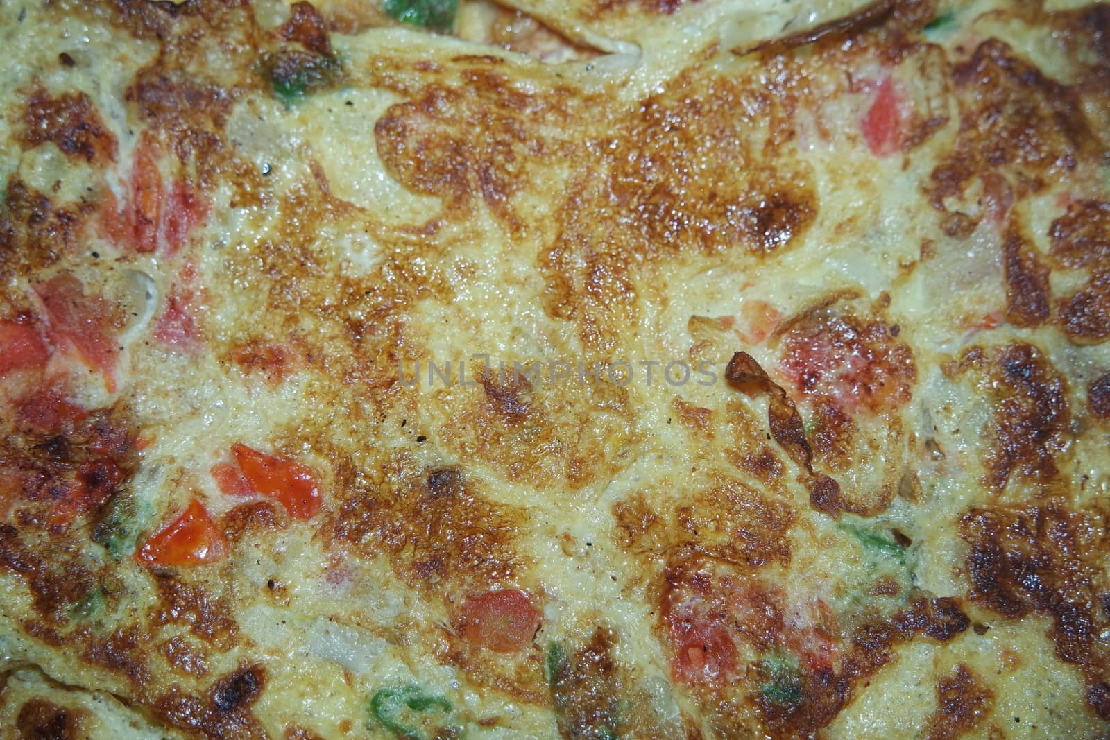 Close-up view with selective focus of egg omelet with peppers and spices sprinkled