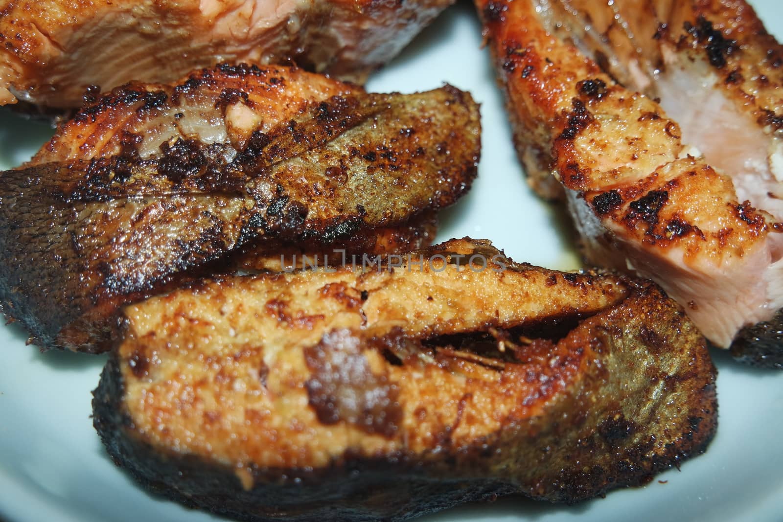 Spicy and crunchy barbecue of fried fish fillet on a white background. Homemade grilled trout fish steaks for health nourishments.