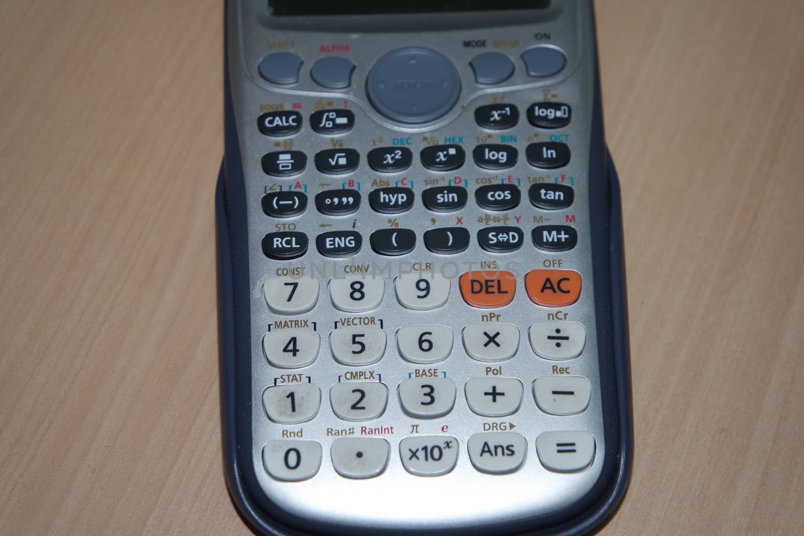 Calculator isolated on a wooden background by Photochowk