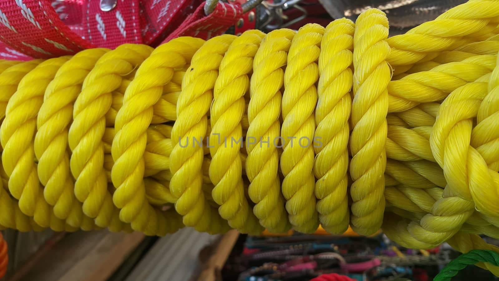 Closeup of bright color braided plastic ropes. Hanks or coil of bright colored plastic rope interwoven which are used for climbing and tightening materials.