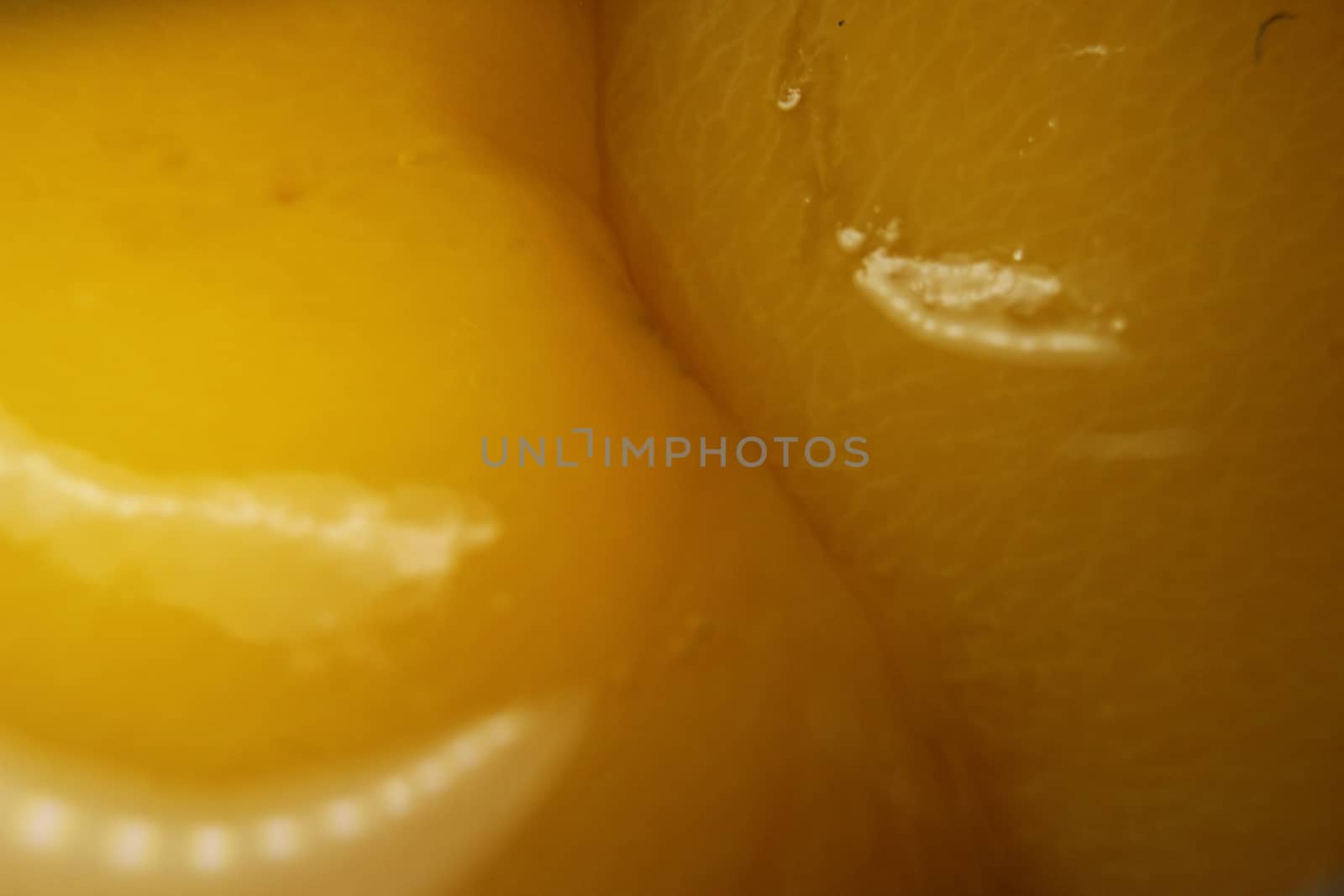 Closeup view with selective focus of yellow peaches slices. Canned peaches halves sprinkled with syrup.