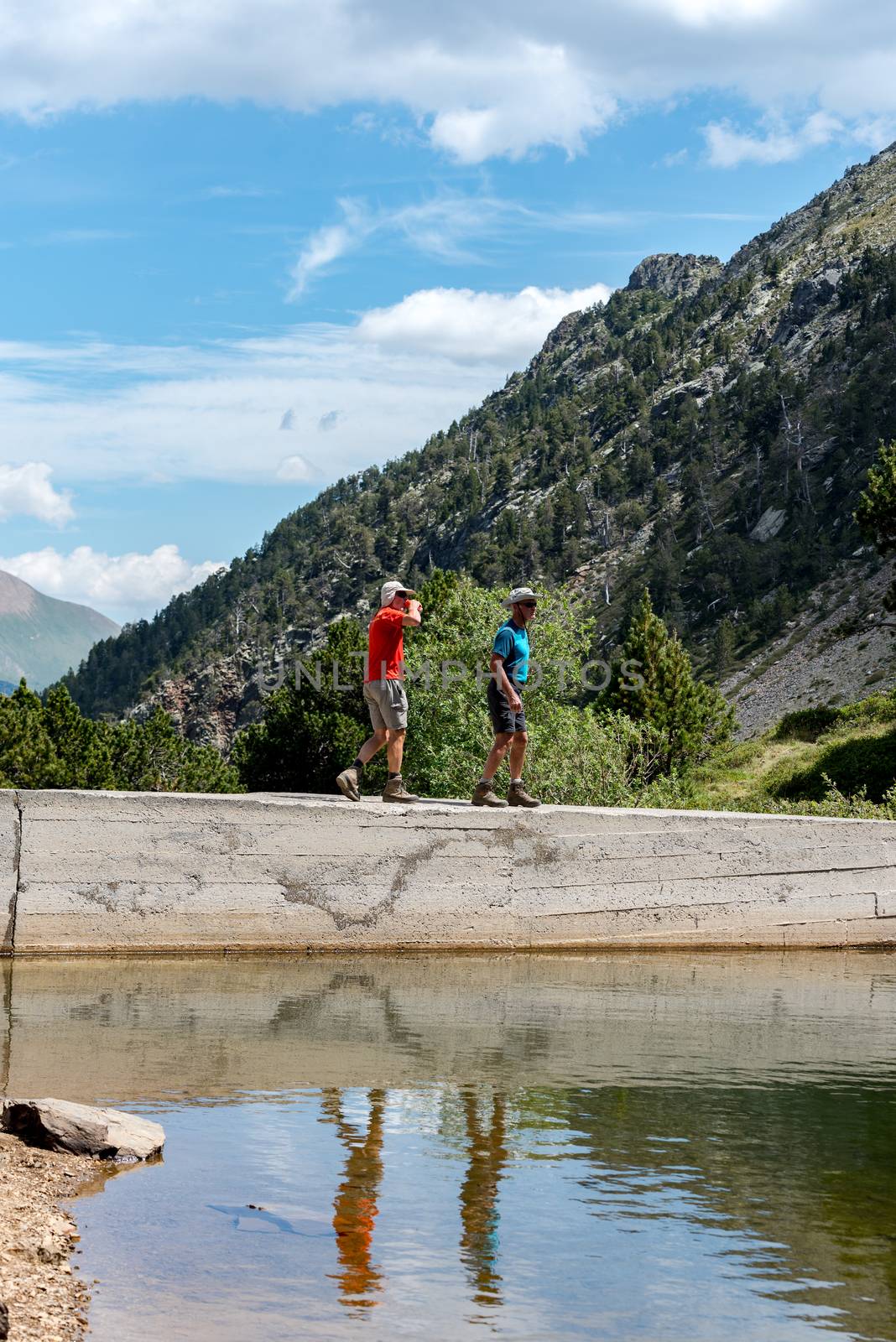 Group of tourists resting at Lago de les Truites in Andorra Pyre by martinscphoto