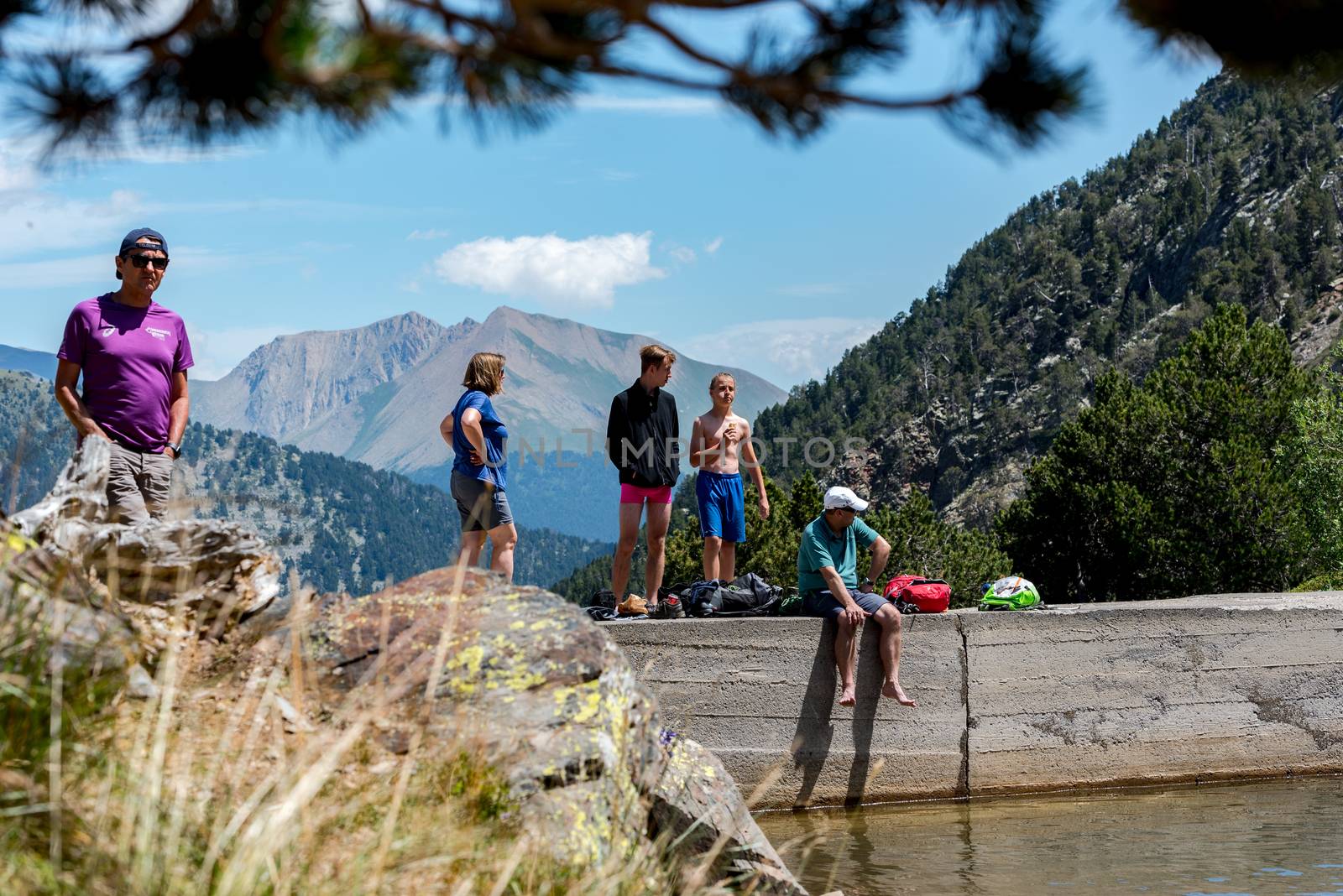 Group of tourists resting at Lago de les Truites in Andorra Pyre by martinscphoto