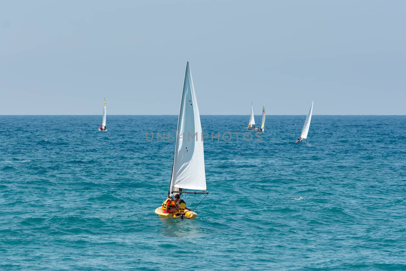 People in boat on the beach in Sitges in summer 2020. by martinscphoto