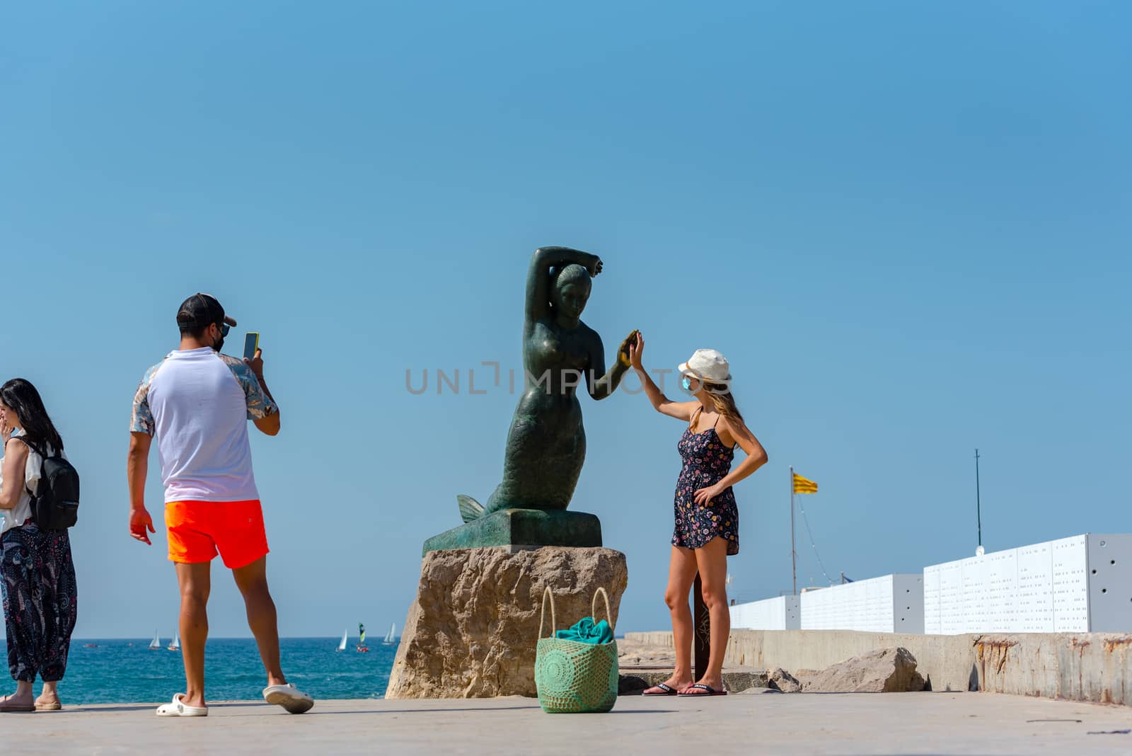 Sitges, Catalonia, Spain: July 28, 2020: Tourist take picture on the beach in Sitges in summer 2020.