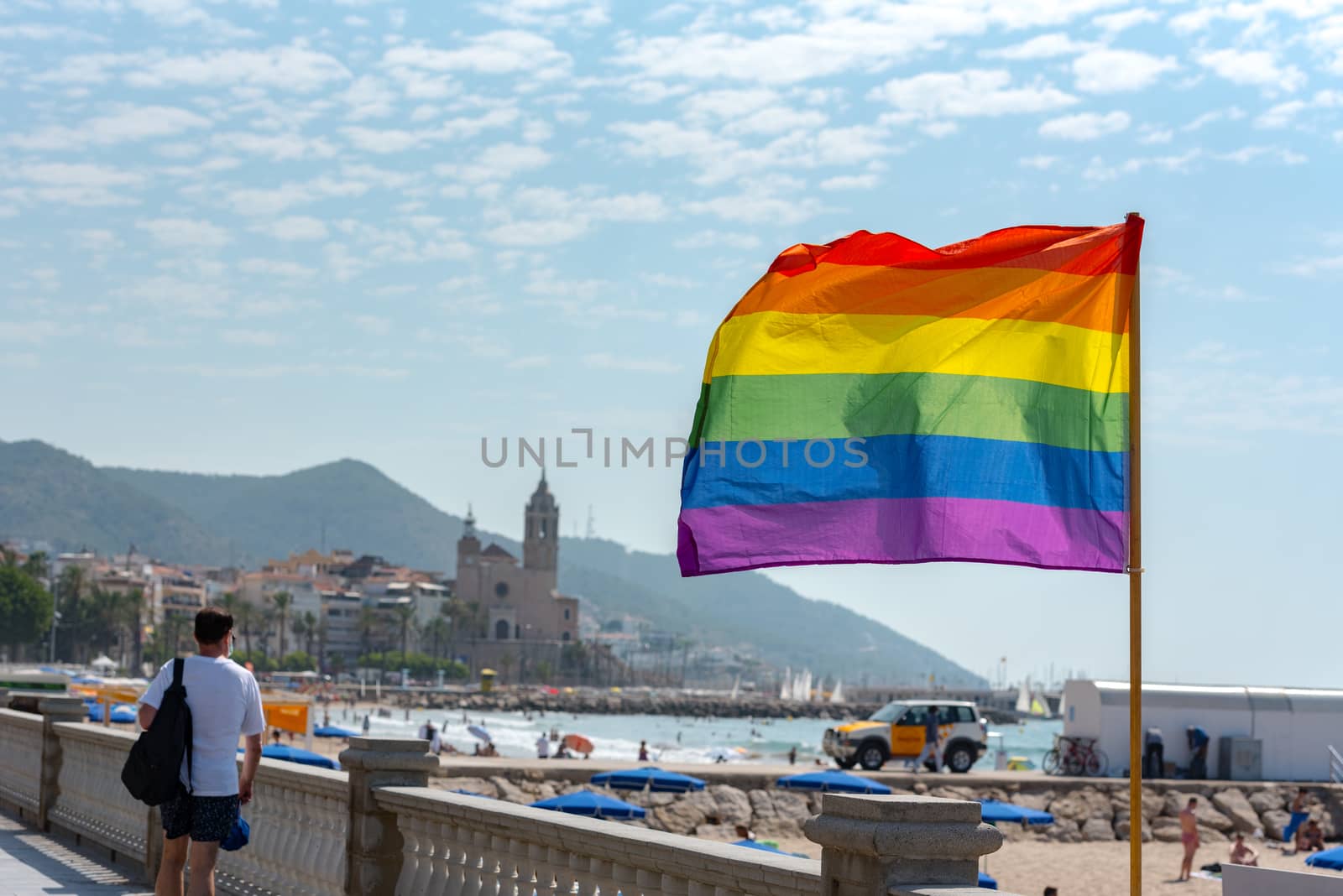 Sitges, Catalonia, Spain: July 28, 2020: Flag gay whit People on the Paseo Maritimo in the city of Sitges in the summer of 2020.