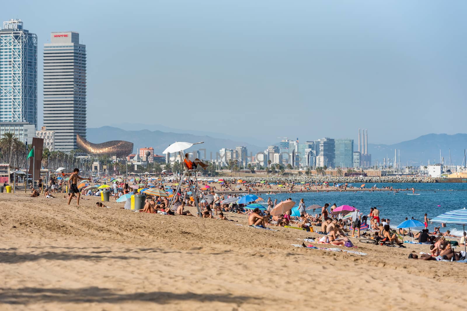 Barcelona, Spain - July 28 2020:  People in the Barceloneta Beach after COVID 19 La Barceloneta in Barcelona, Spain.