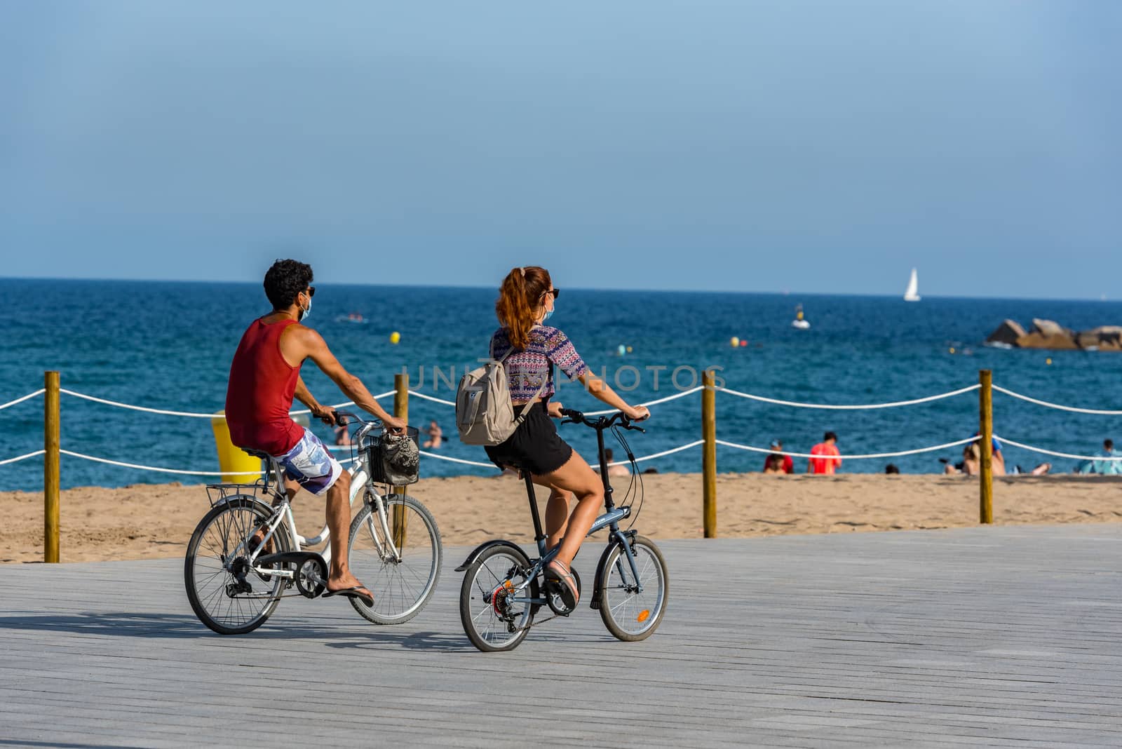 Barcelona, Spain - July 28 2020:  People ride bikes after COVID 19 LA Barceloneta in Barcelona, Spain.